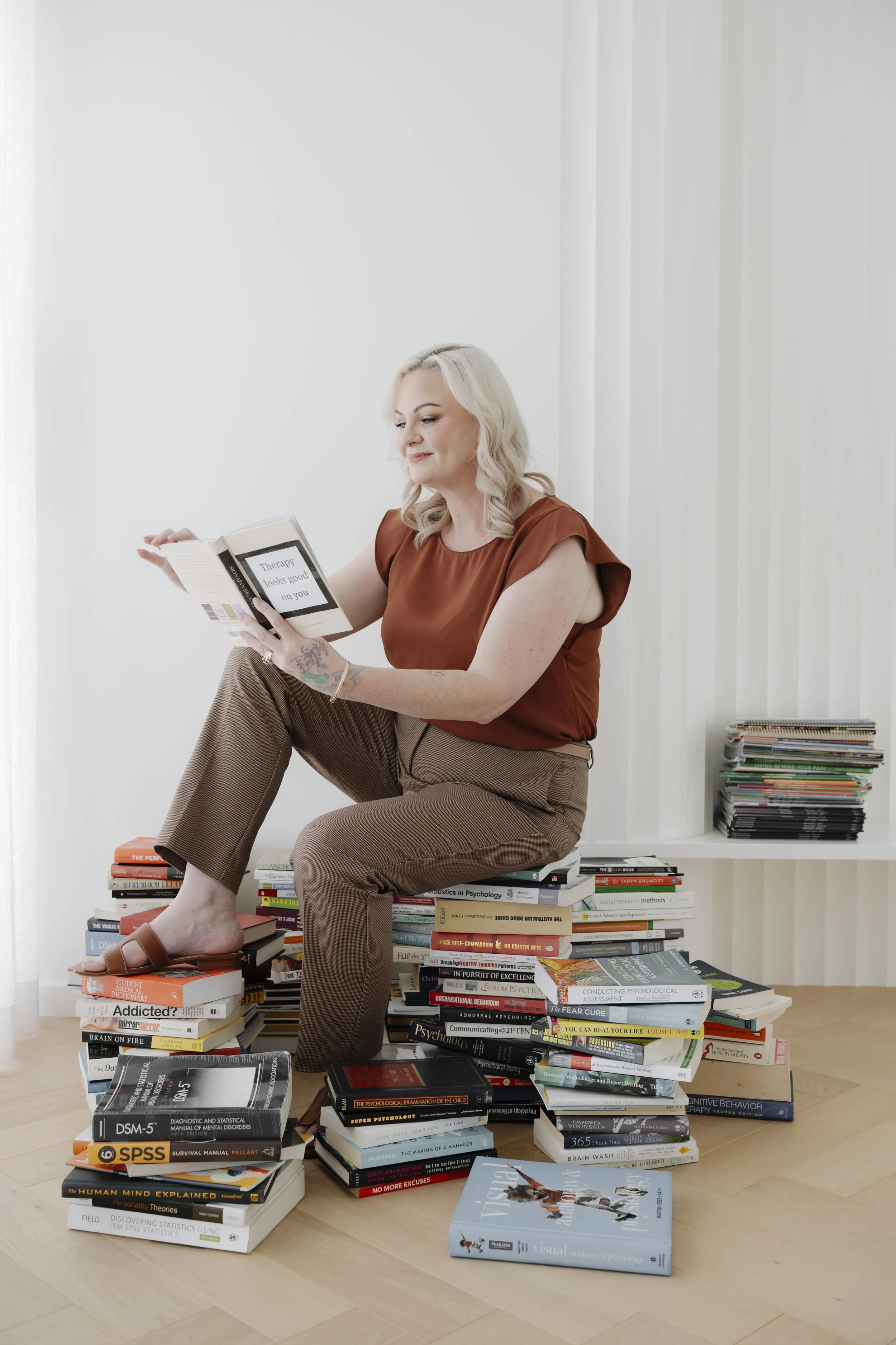 Shannon sitting on a pile of books