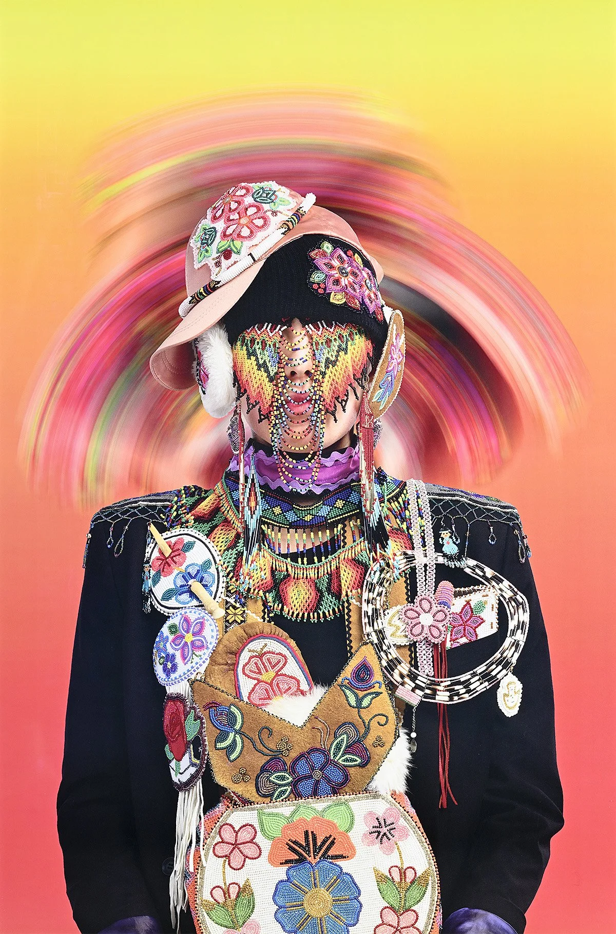 Person dressed in elaborate, colorful embroidered accessories and garments, with a blurred, swirling pink, orange, and yellow background.