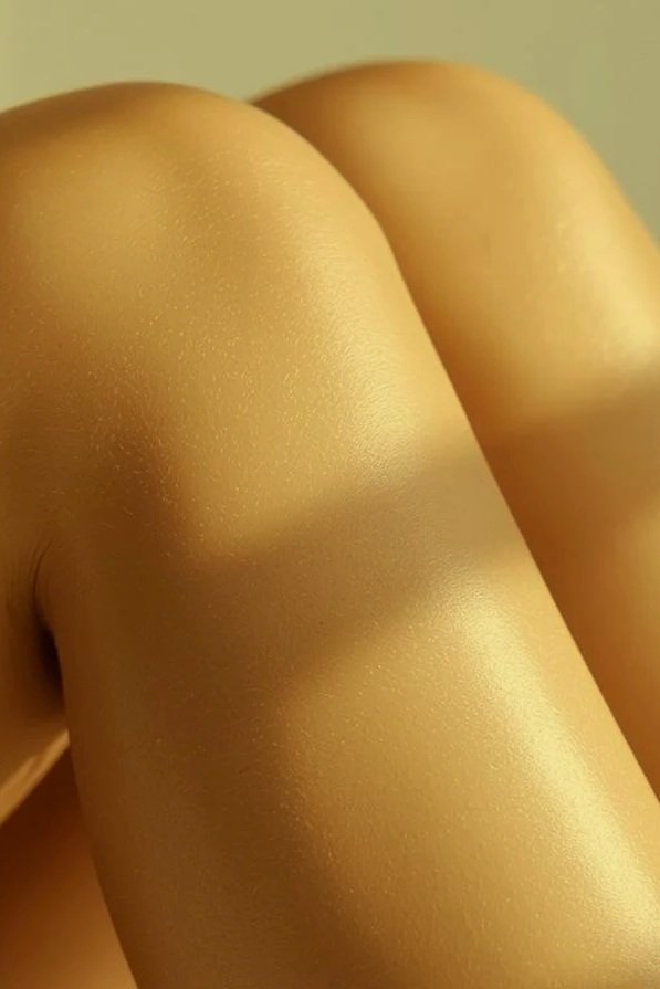 Close-up of a person's bare back and shoulder with smooth, sugar waxed skin.