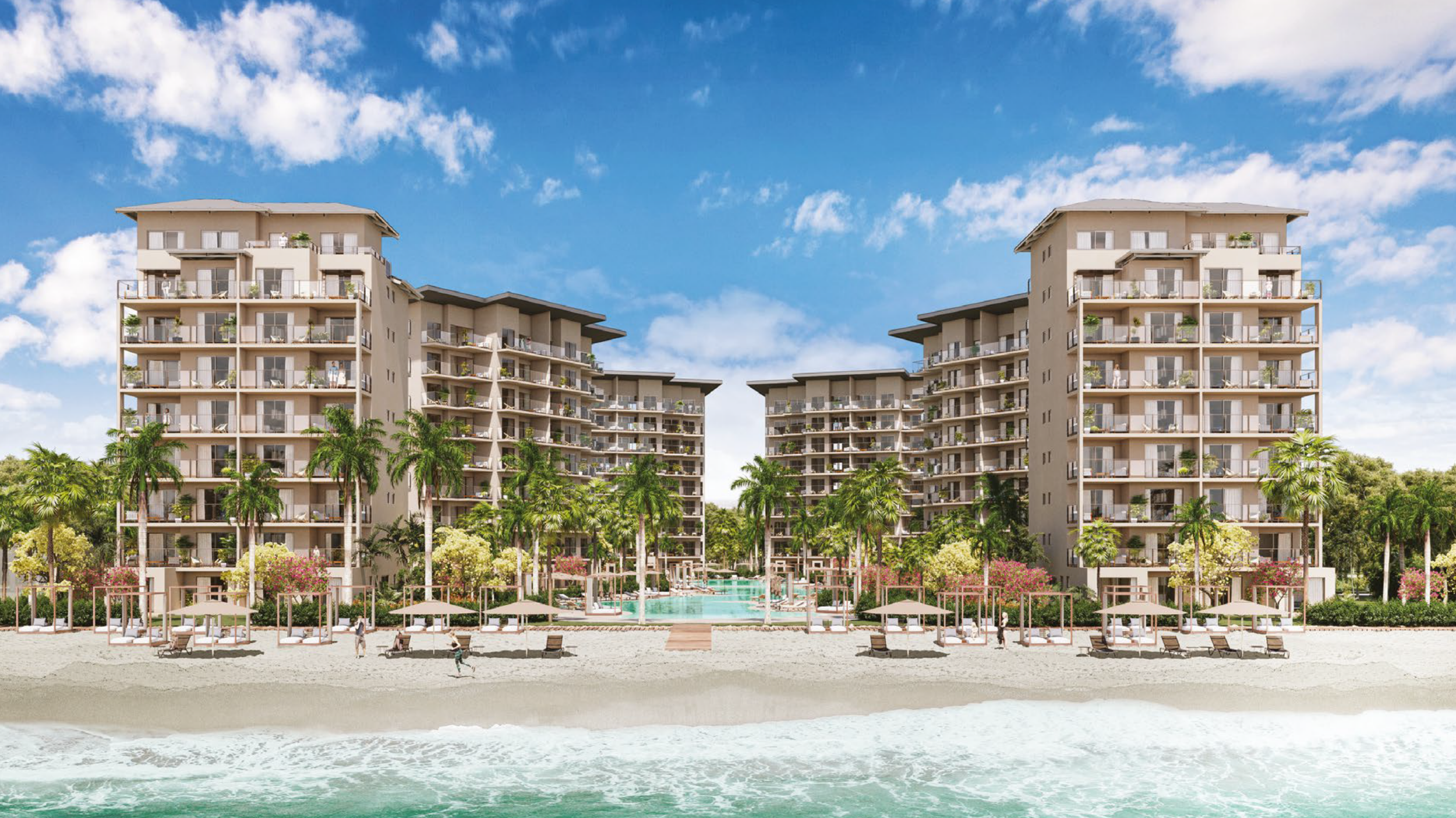A modern beachfront resort with two high-rise buildings surrounded by lush trees, a swimming pool, and lounge chairs on a sandy beach under a partly cloudy sky.