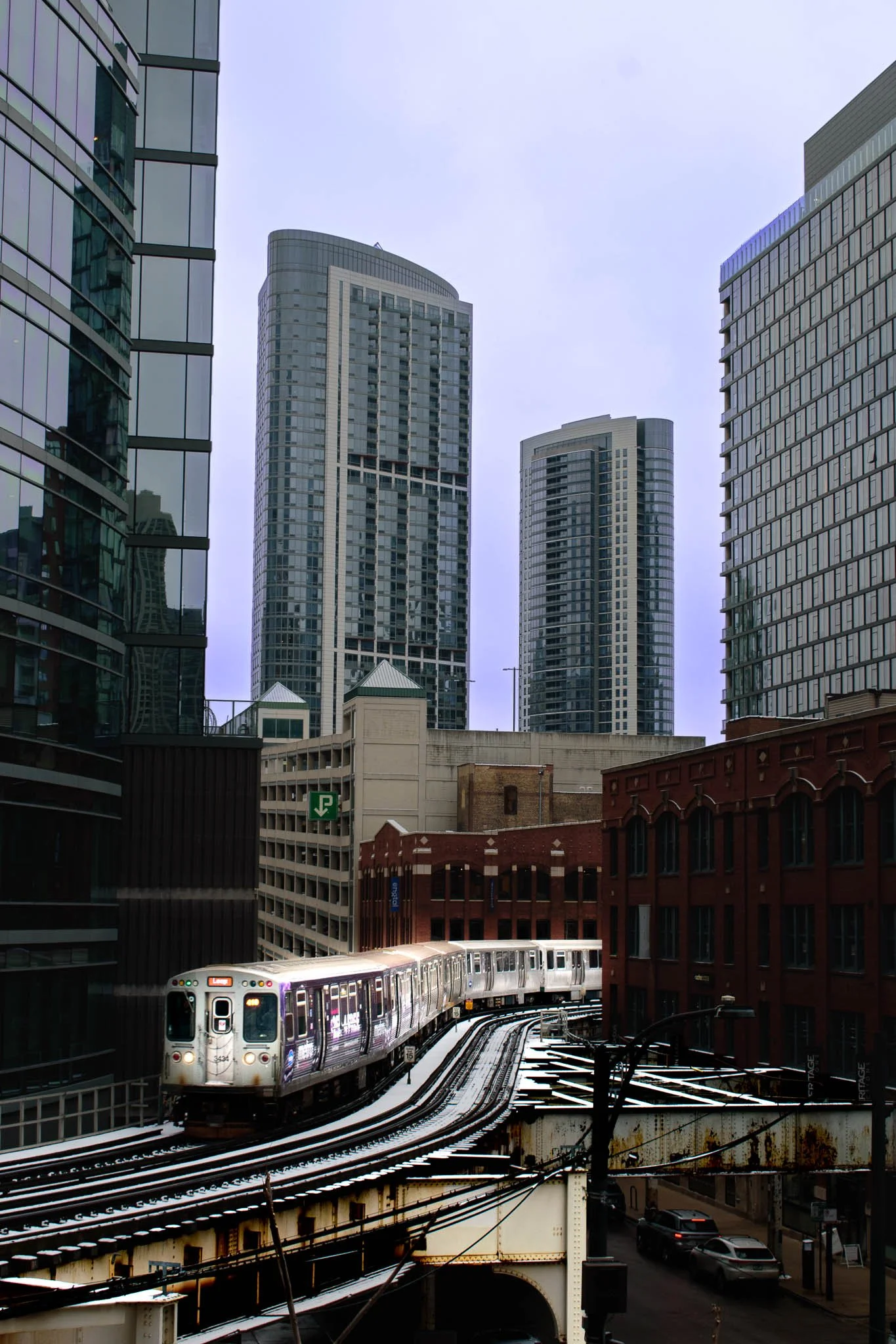 High-rise buildings and a train on elevated tracks in an urban cityscape.