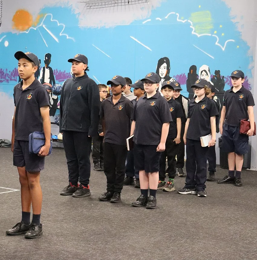 A group of young boys standing in a line wearing uniforms
