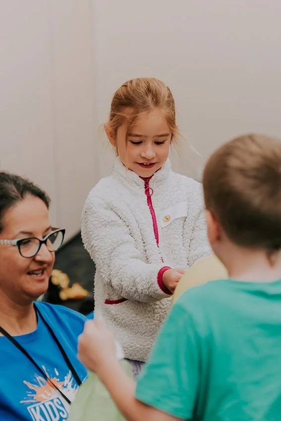 Five year old girl wearing a white fluffy jumper playing