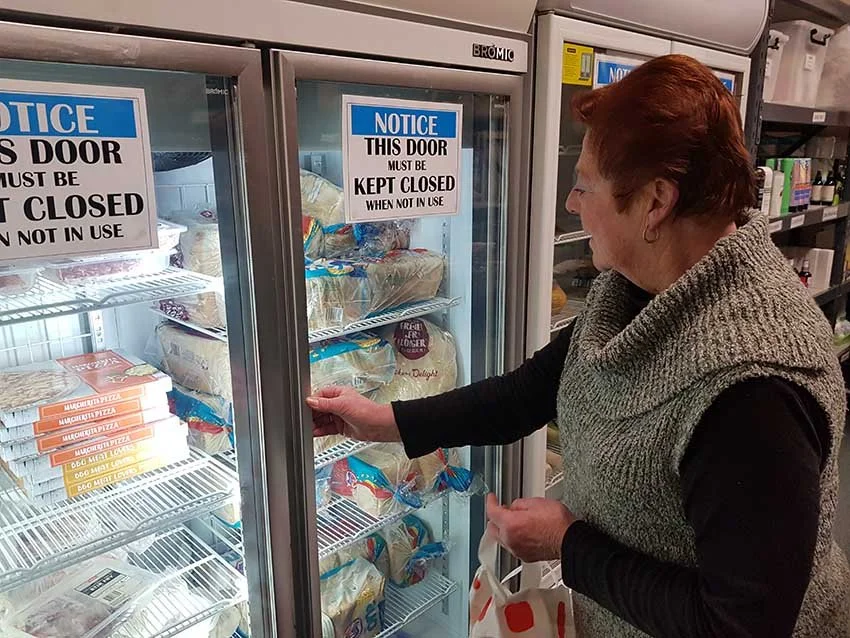 Volunteer lady filling fridge in berwick church food pantry