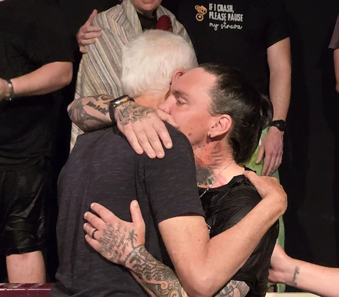 Two men hugging after baptising the younger man in the baptstry