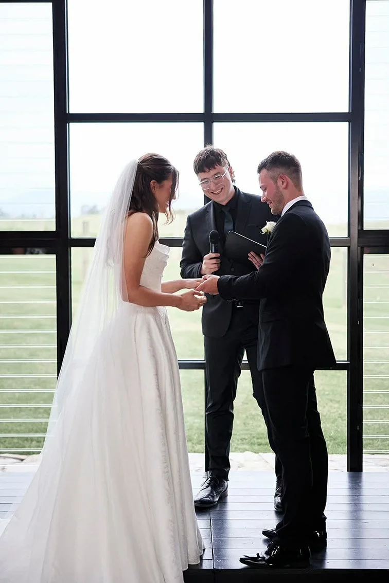 Bride and groom standing at the alter putting rings on