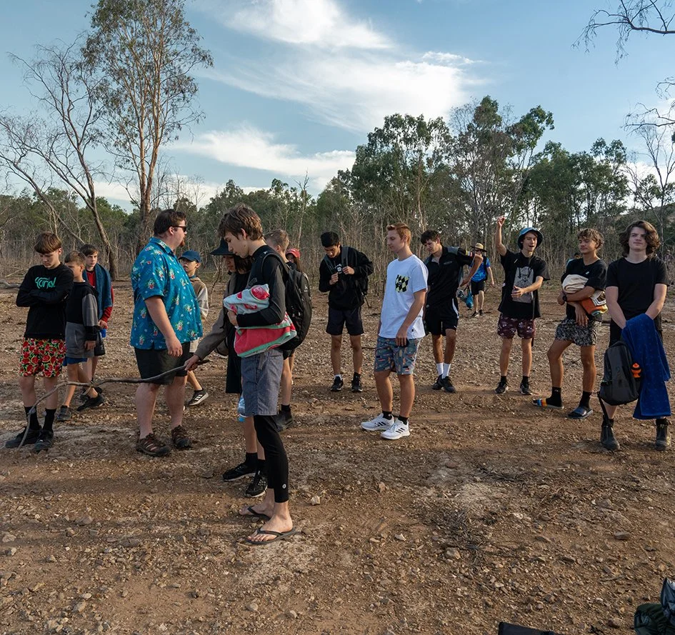 Boys walking in the bush on barren land