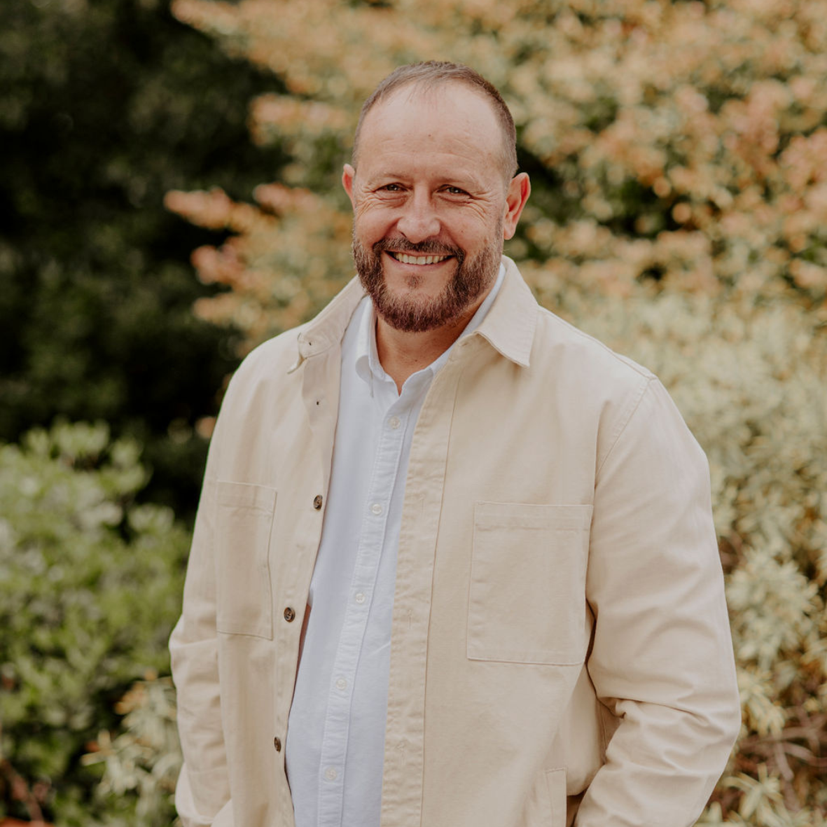 Senior Pastor Braam Botha wearing a white shirt and beige jacket