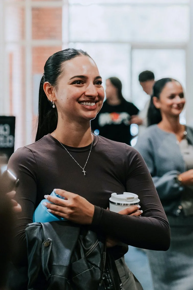 Young lady in her twenties wearing a brown long sleeve top with dark hair talking about the Alpha Course