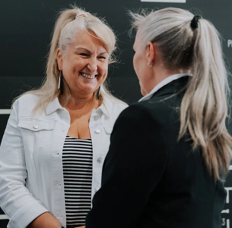 Two ladies talking in their sixties wearing casual clothes