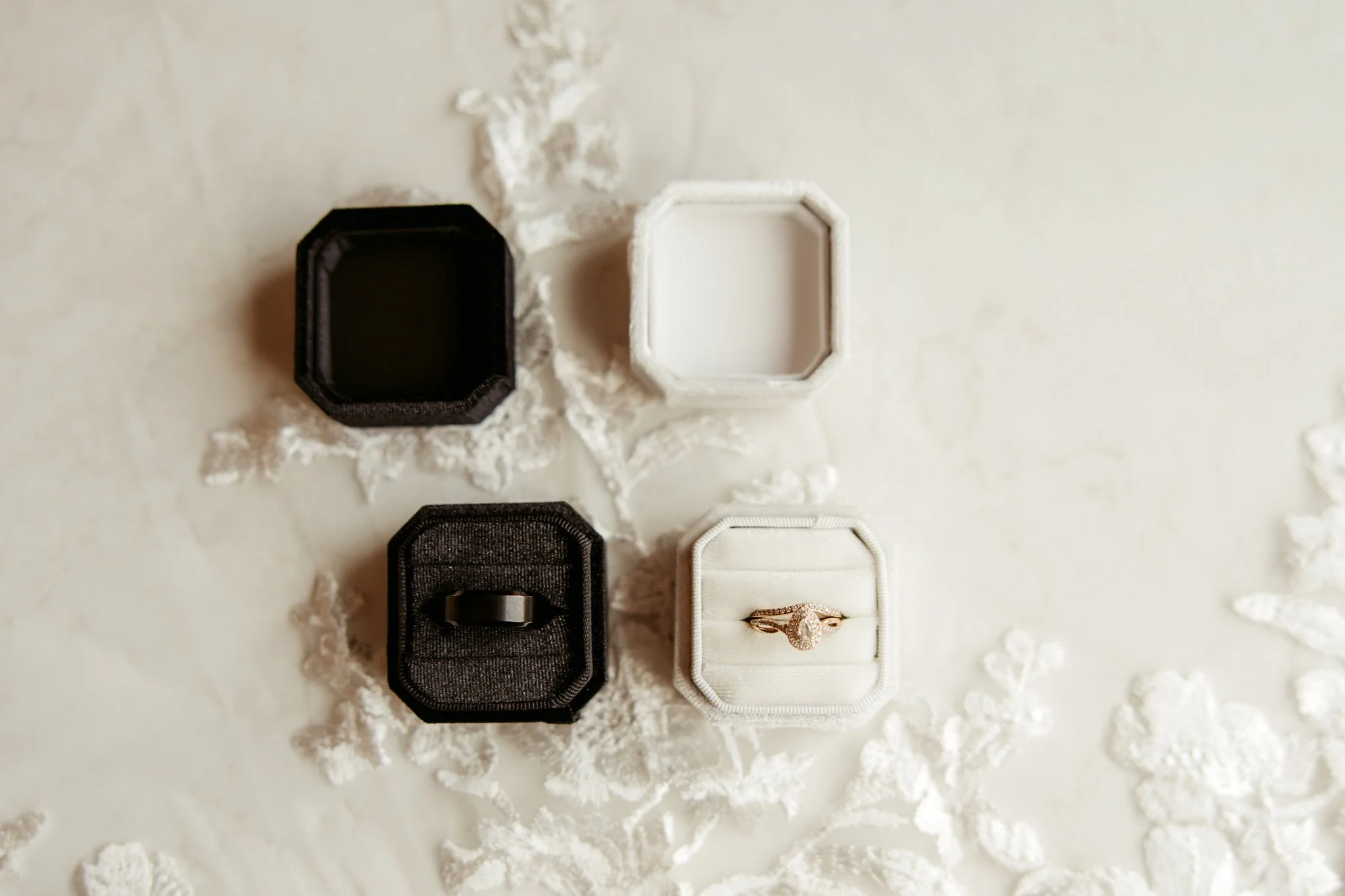 An open jewelry box with a diamond ring inside, placed on a white surface with scattered snowflake-patterned decorations.