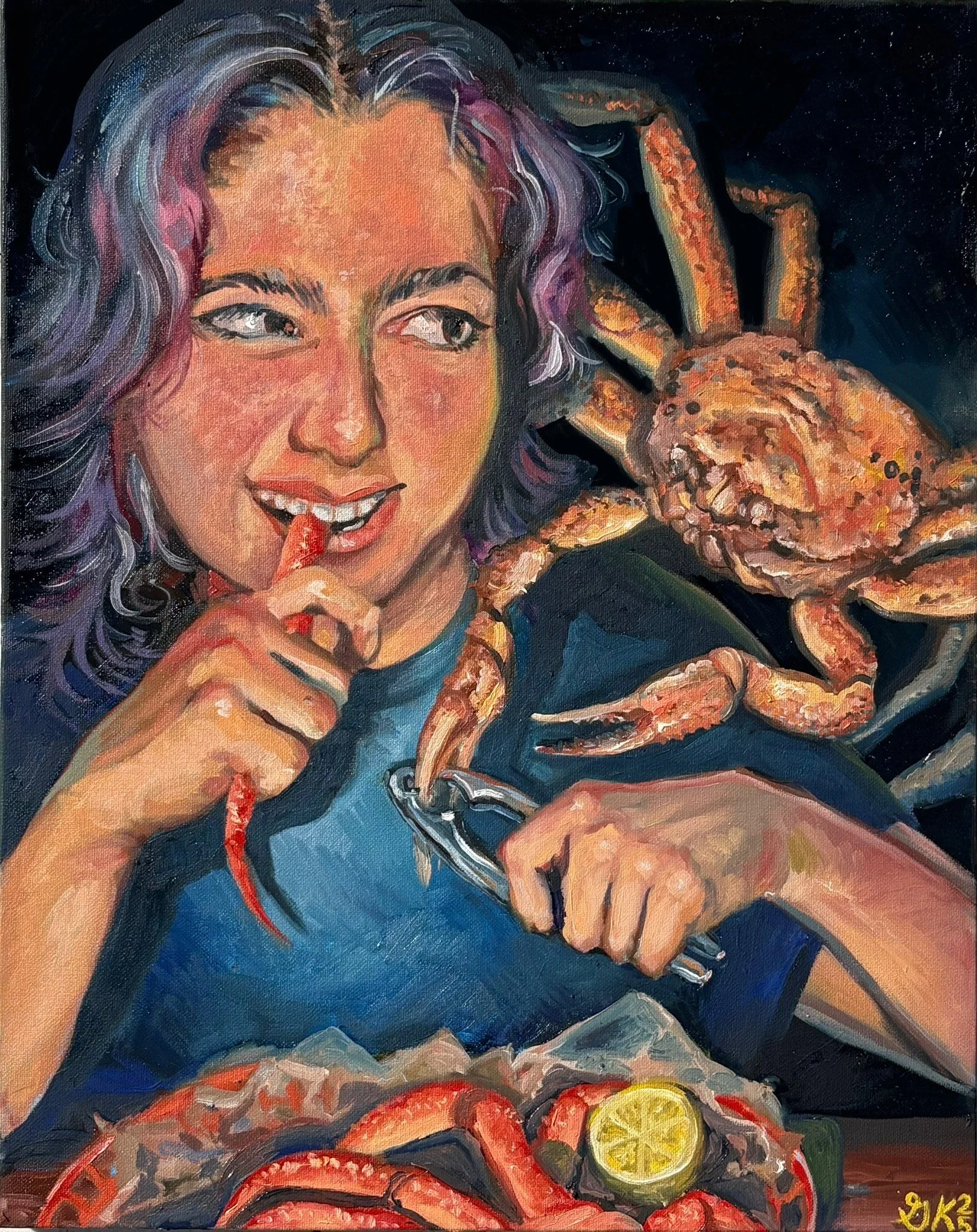 A woman with wavy, multicolored hair smiling while holding a crab leg with her right hand and a seafood cracker in her left hand. There are cooked crab parts and sliced lemon on a plate in front of her.