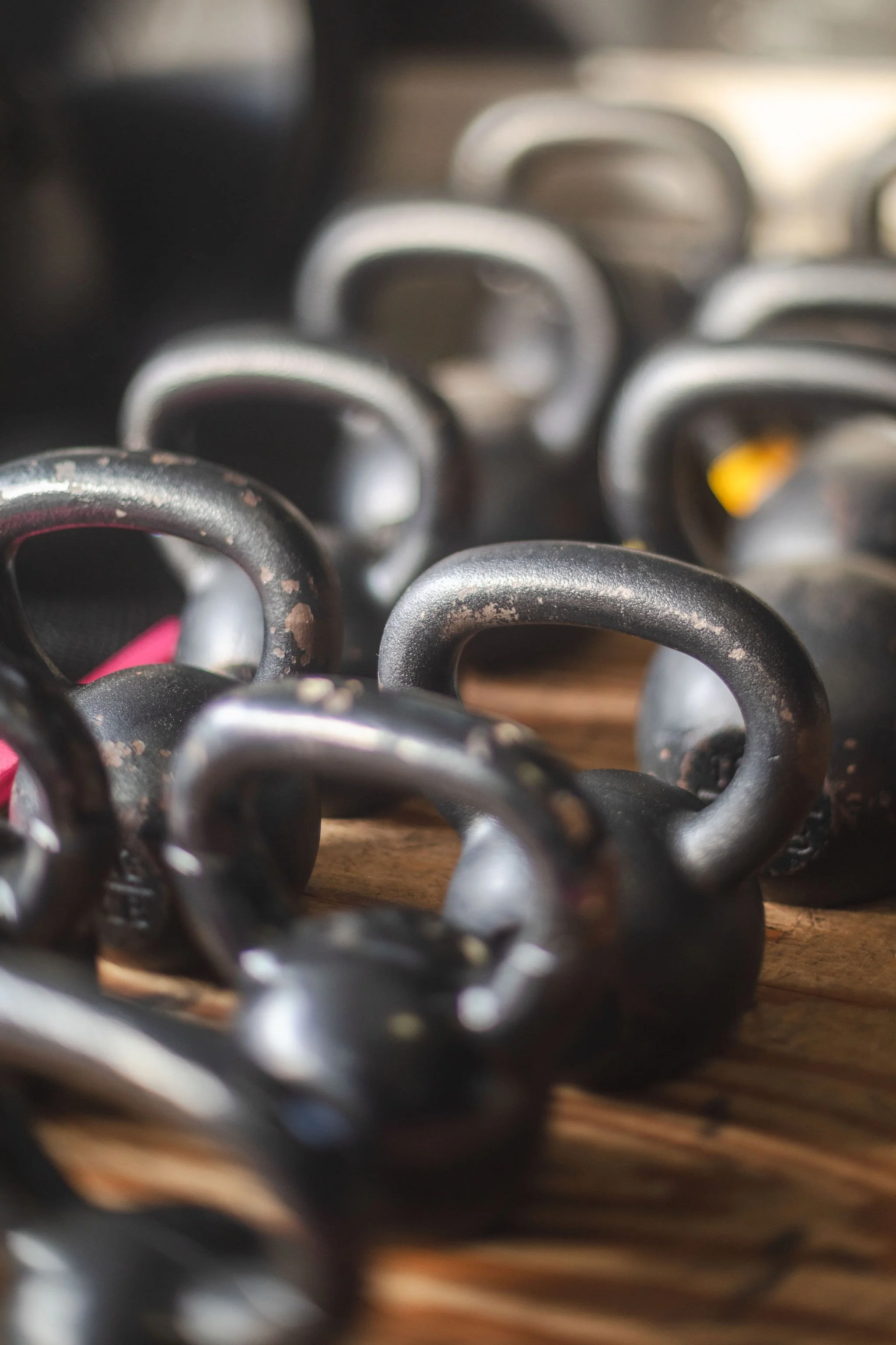 Close-up of golf club iron heads stacked together, some showing signs of wear and rust.