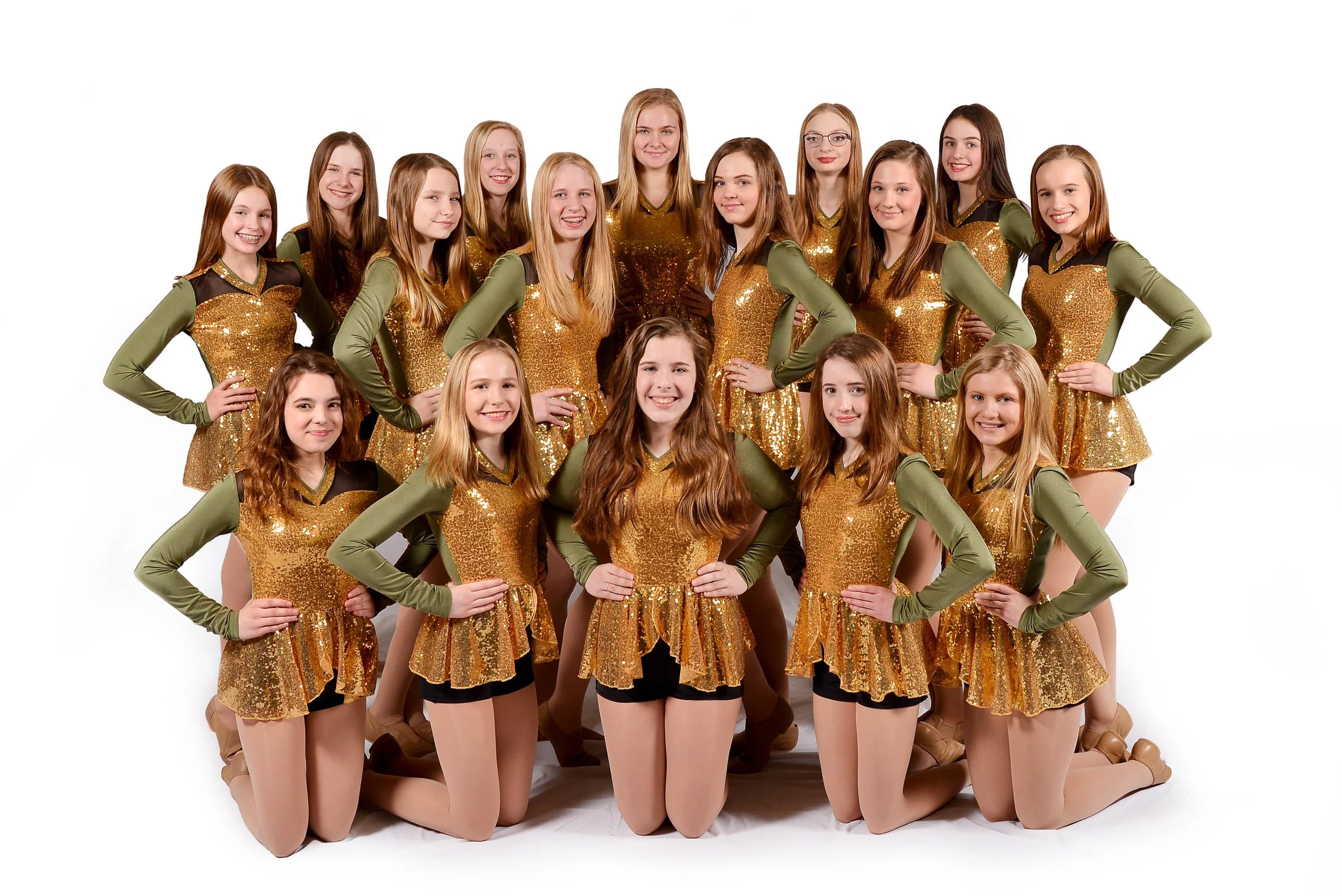 A group of young female dancers in matching gold and green outfits posing together on a white background.