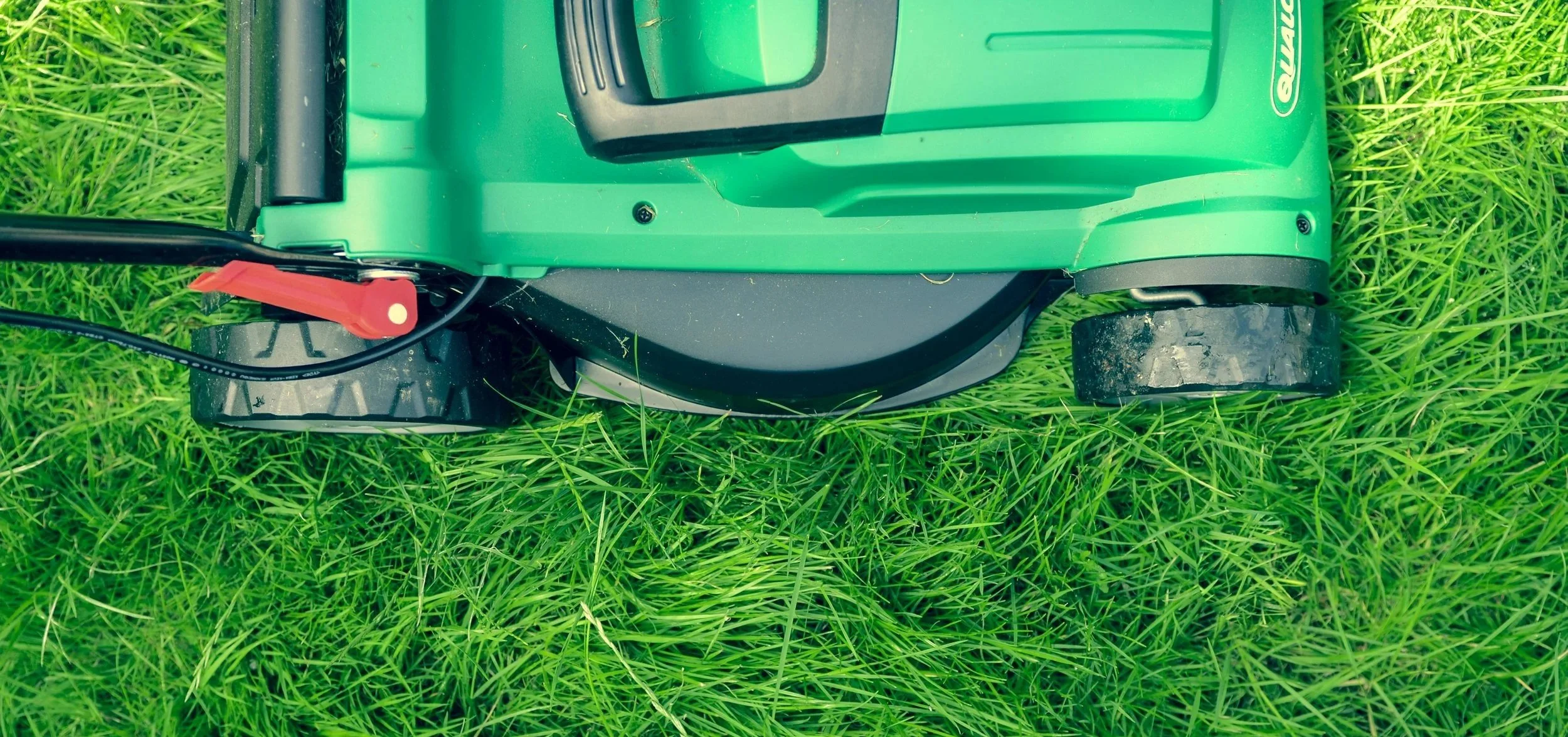 A lawnmower on lush, green grass.