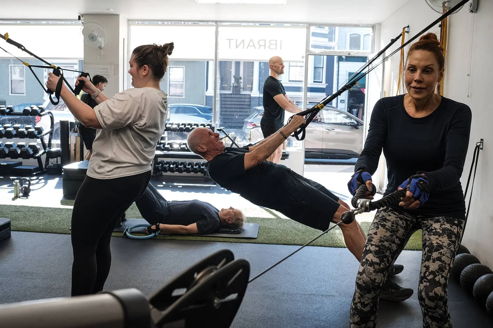 People working out at a gym using resistance bands and other equipment.