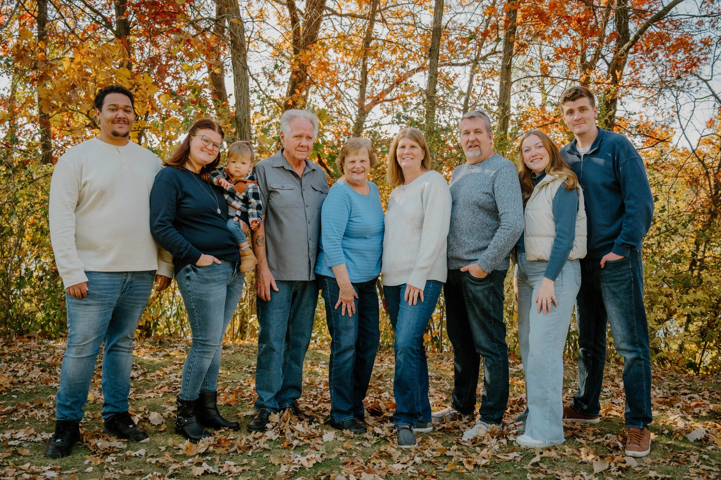 Family outdoor portrait during fall with colorful autumn leaves background