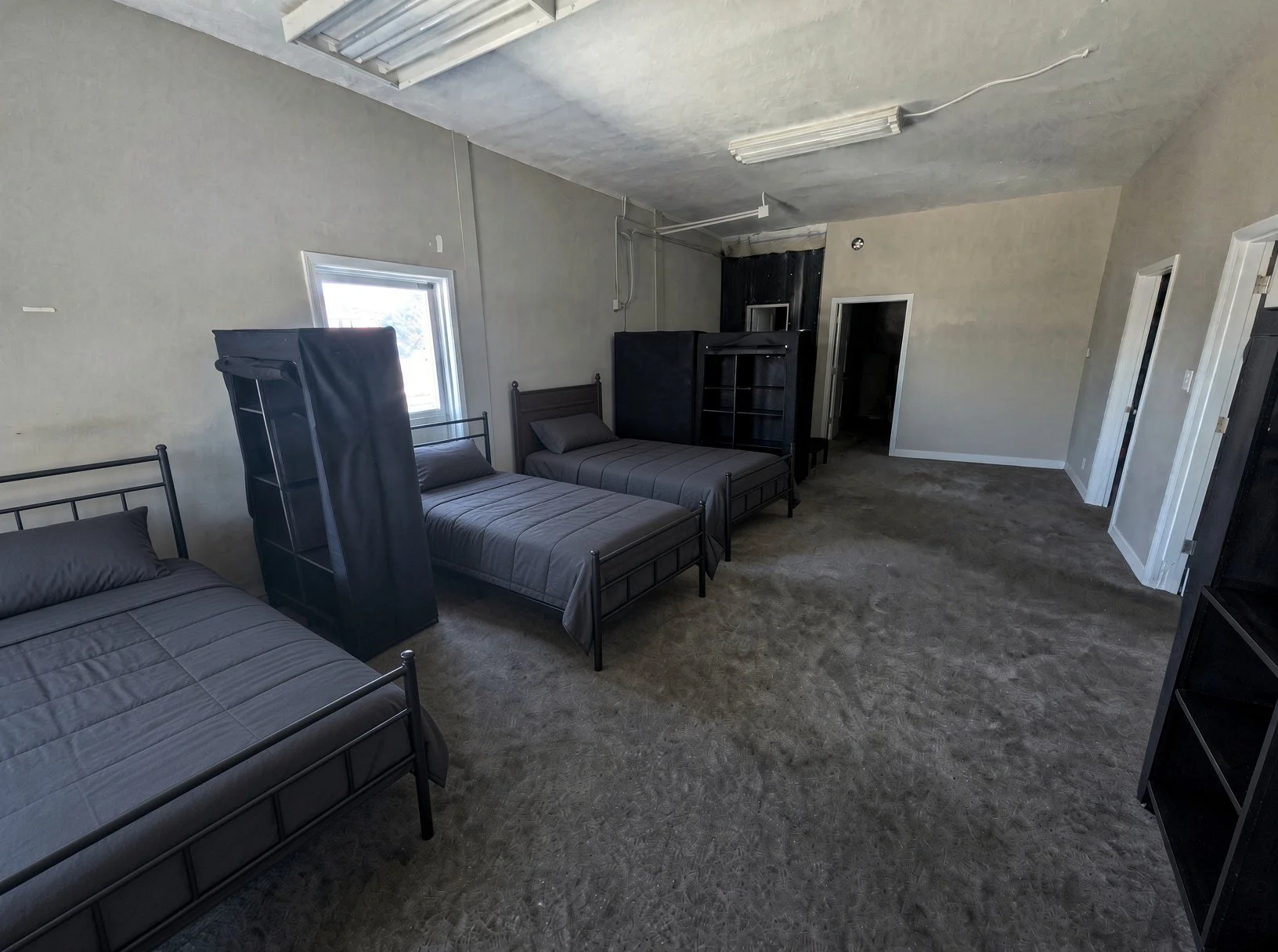 Shared bedroom with three beds at Wolf on Main sober living home