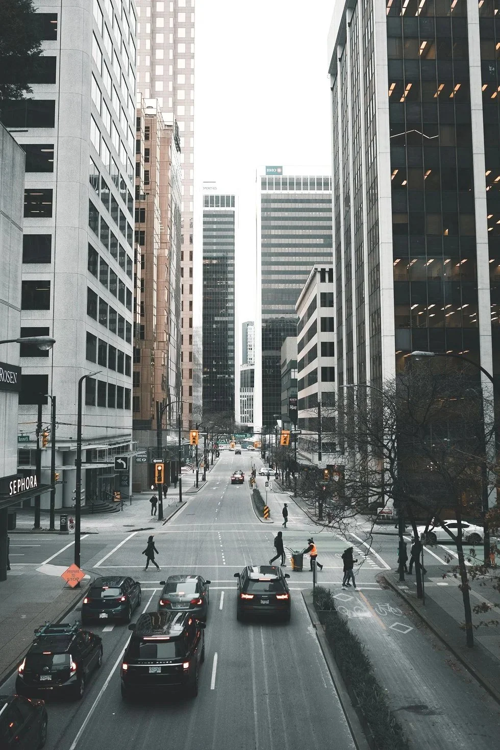 A downtown Vancouver street with office buildings, traffic, and pedestrians, representing Network Security Solutions in Vancouver