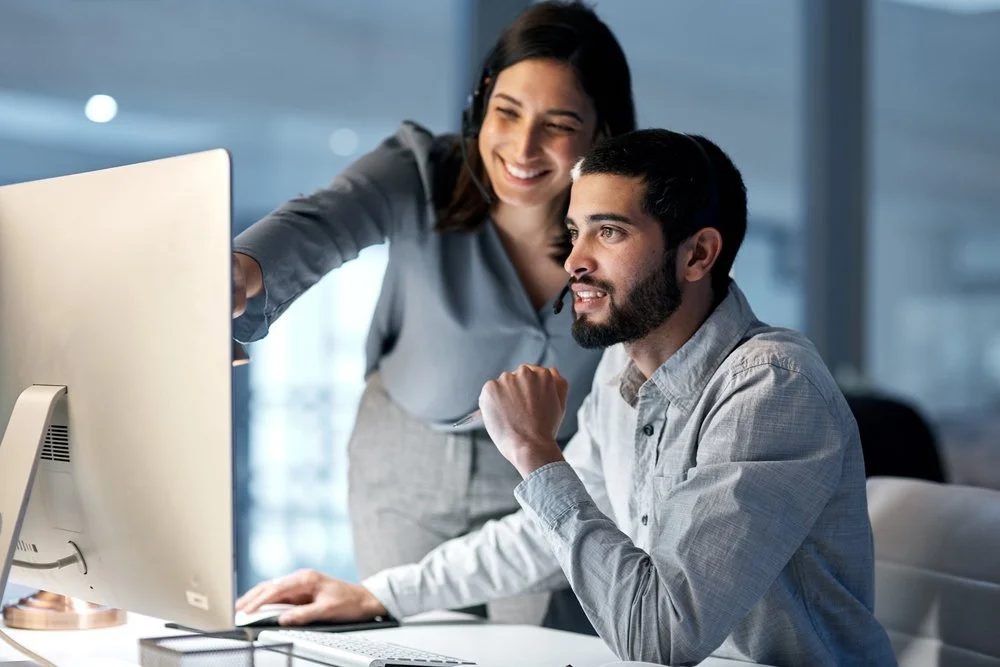 Small business owner getting IT support for small business from a Gennix technician reviewing a laptop in a Lower Mainland office