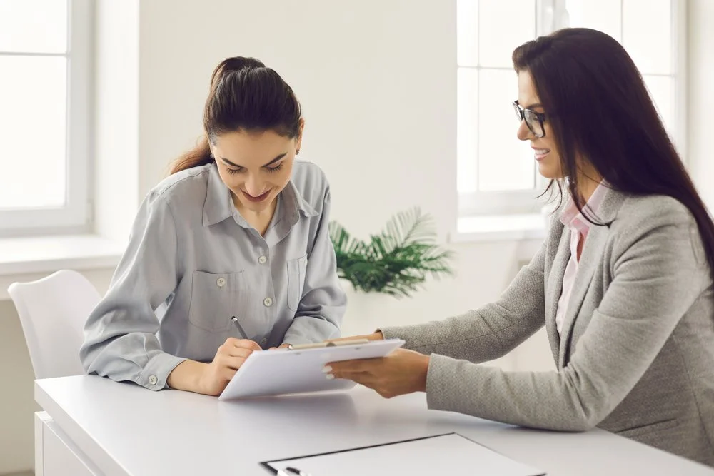 Business owner researching how to choose a managed IT provider while reviewing a checklist with a Gennix consultant in a Lower Mainland office
