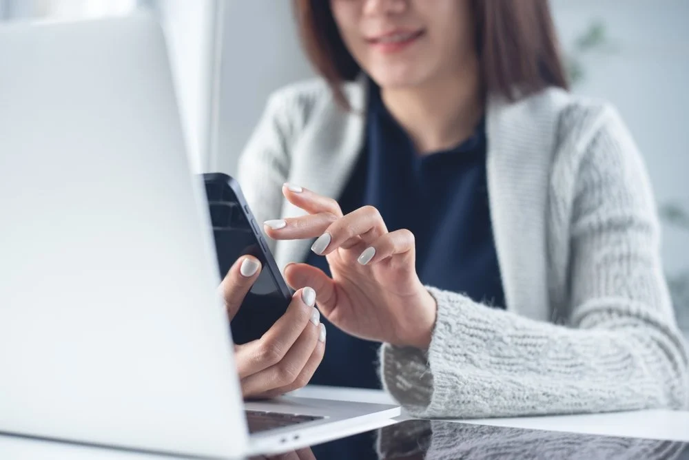 Employee using Microsoft Teams on a laptop and smartphone showing the benefits of using Microsoft Teams for remote and hybrid small business communication