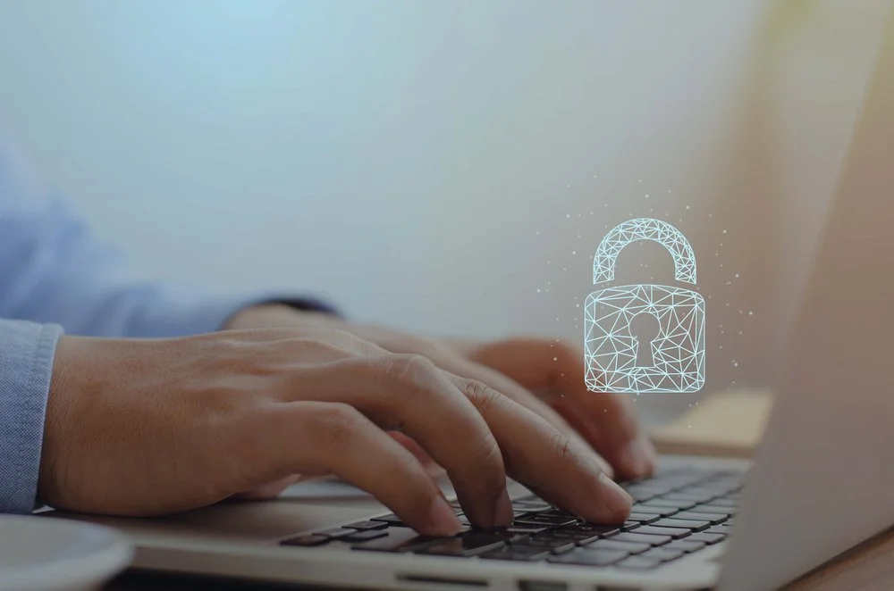 Small business owner reviewing a cyber security insurance policy on a laptop to protect against data breaches and ransomware attacks