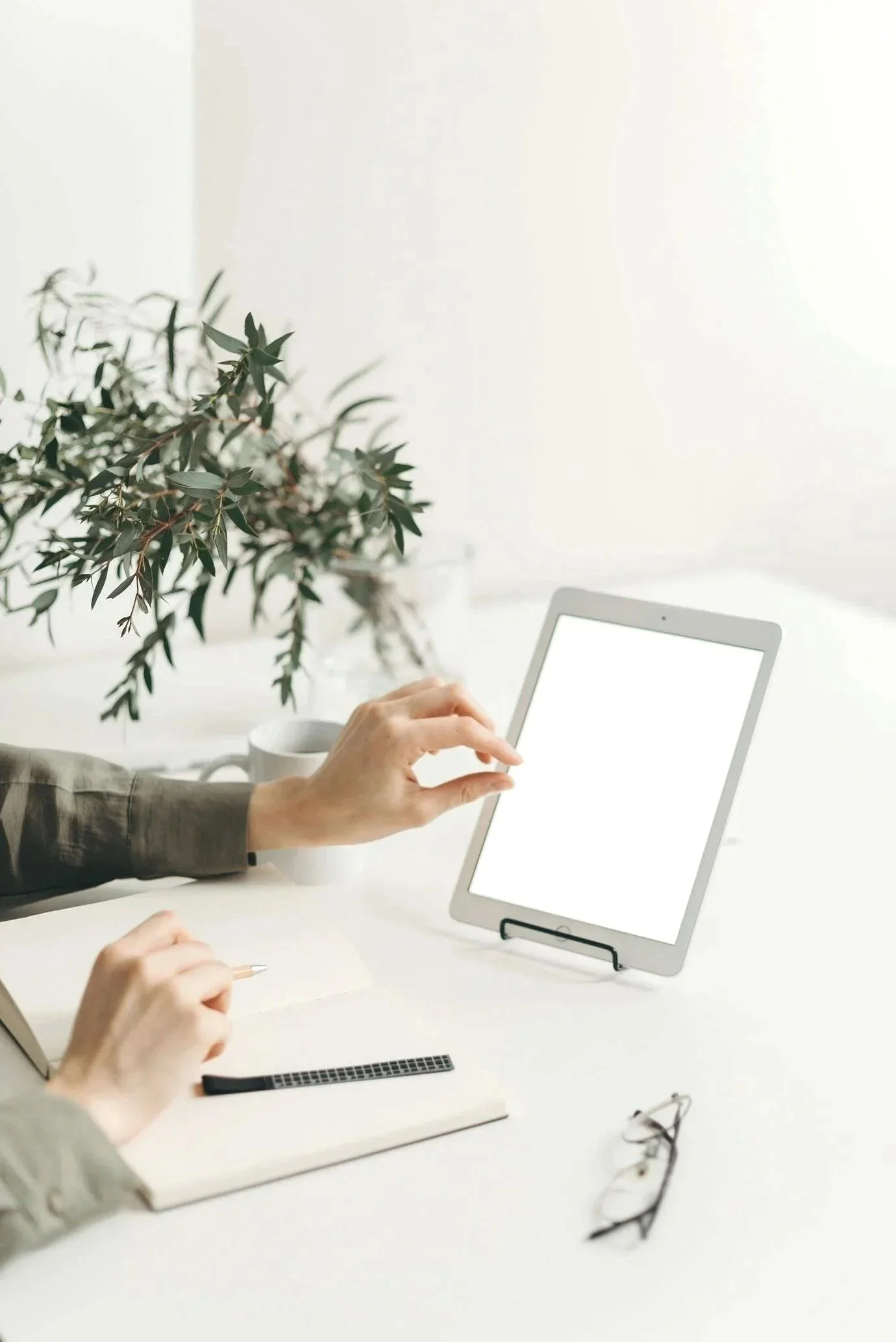 Gennix employee using a tablet and notebook at a desk while providing managed IT services for manufacturing businesses in Vancouver