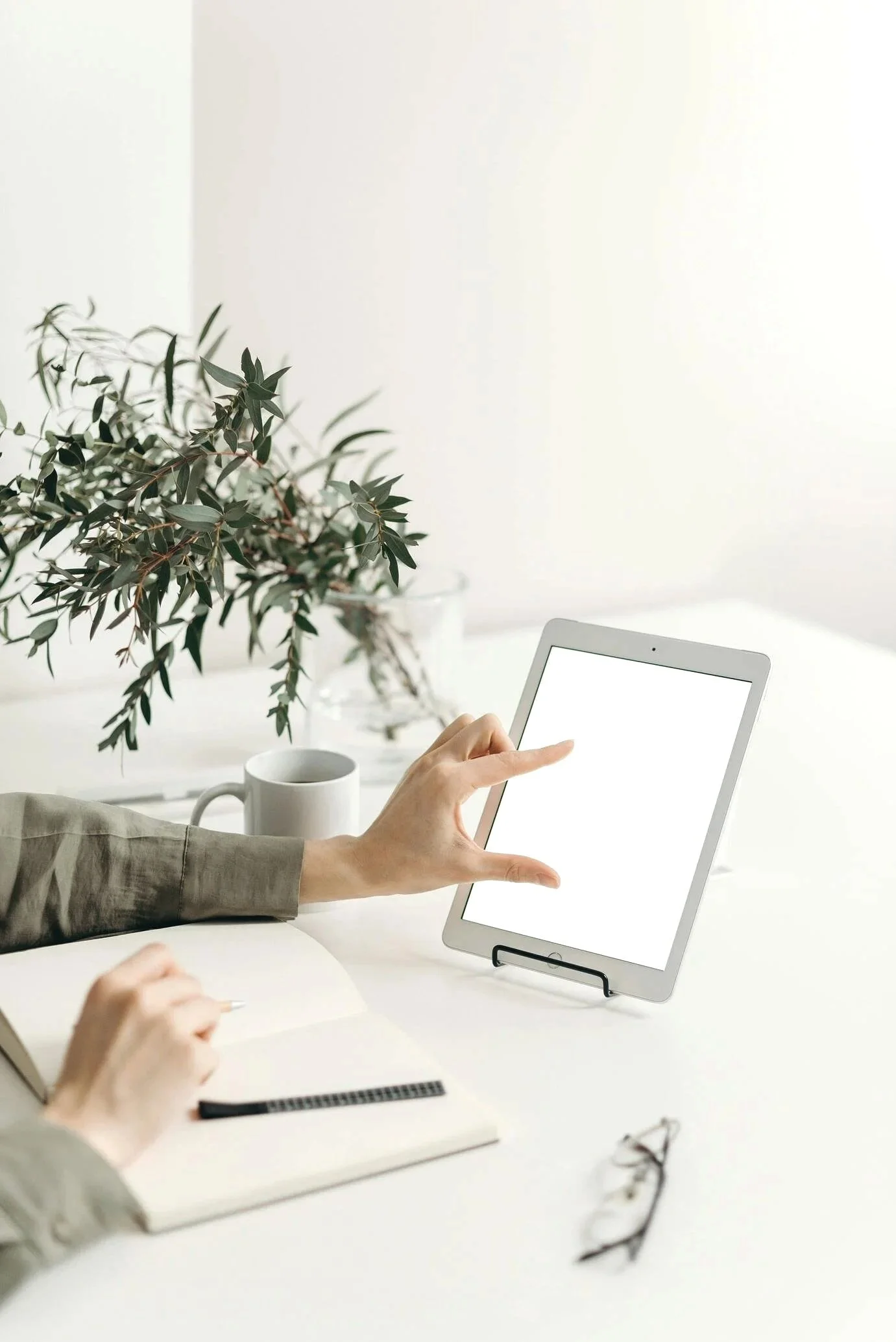 Gennix employee using a tablet and notebook at a desk while delivering managed IT services for small business in Vancouver