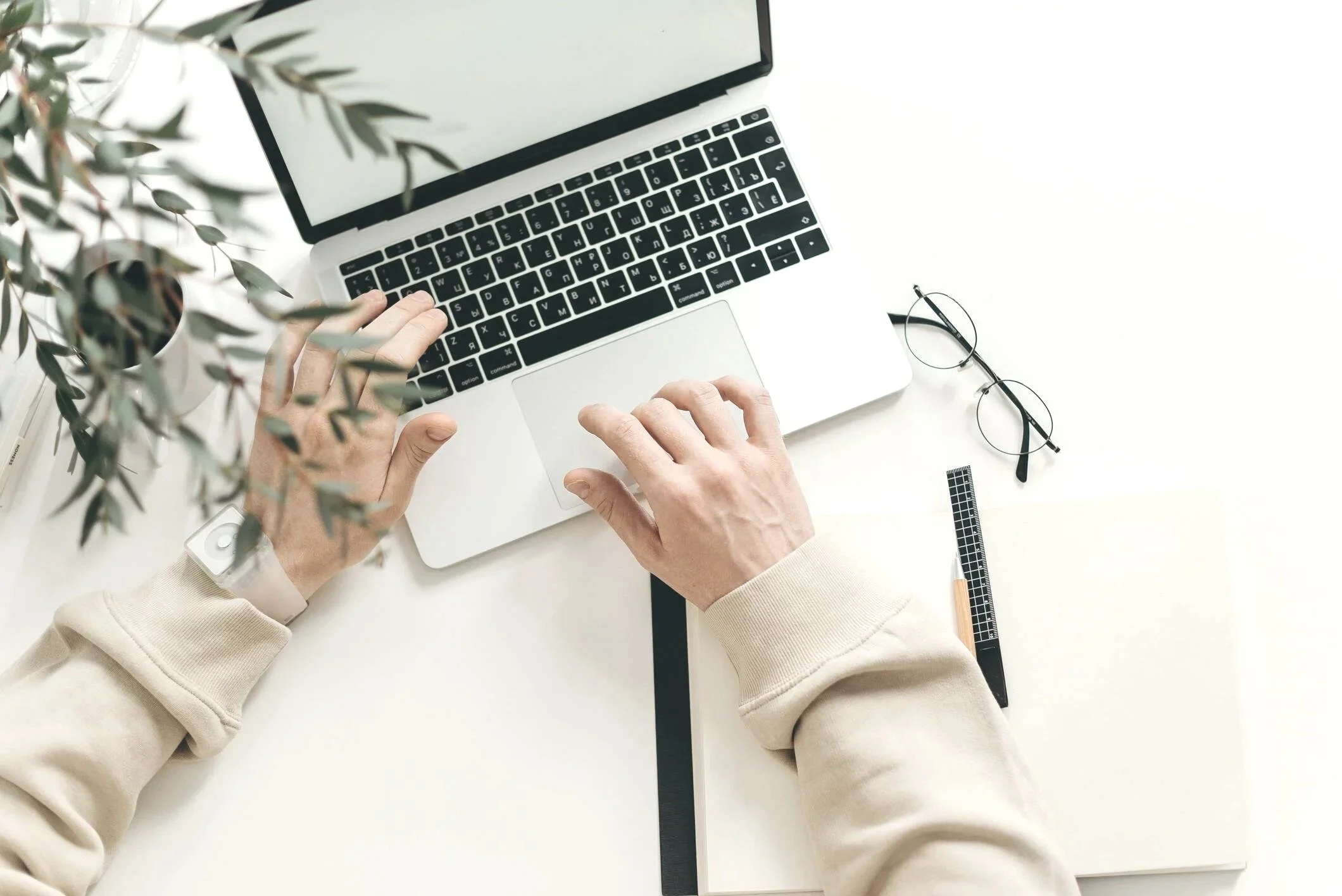 Top-down view of a Gennix employee working on a laptop while delivering Managed IT Services Vancouver solutions for a local business client.