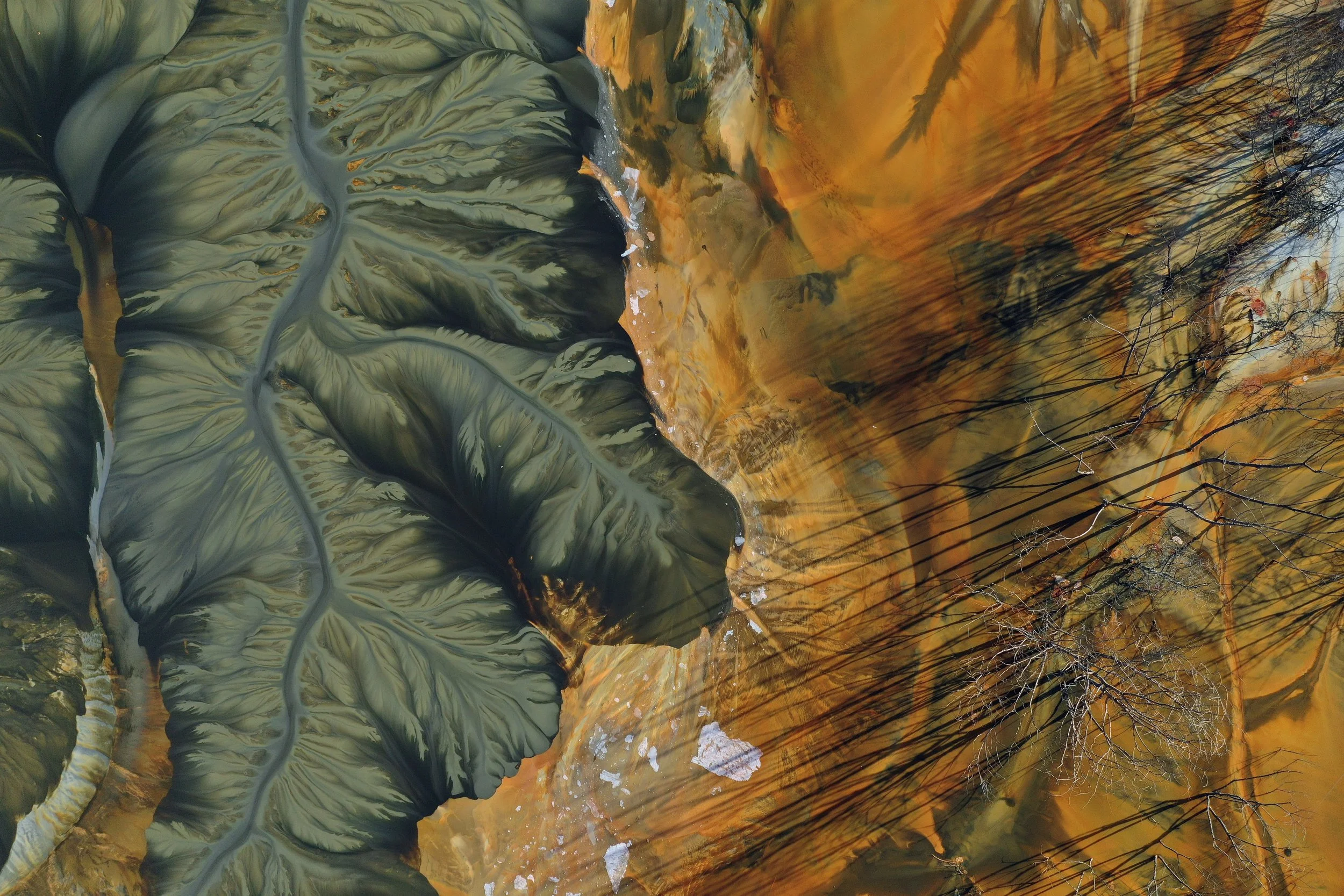 Aerial view of a copper mining residual. Showing blended colours of amber and sage green.