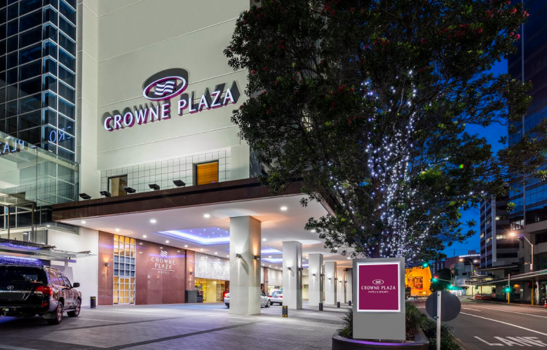 The driveway of the Crown Plaza resort with bright LED lighting and an elegant sign welcoming guests.