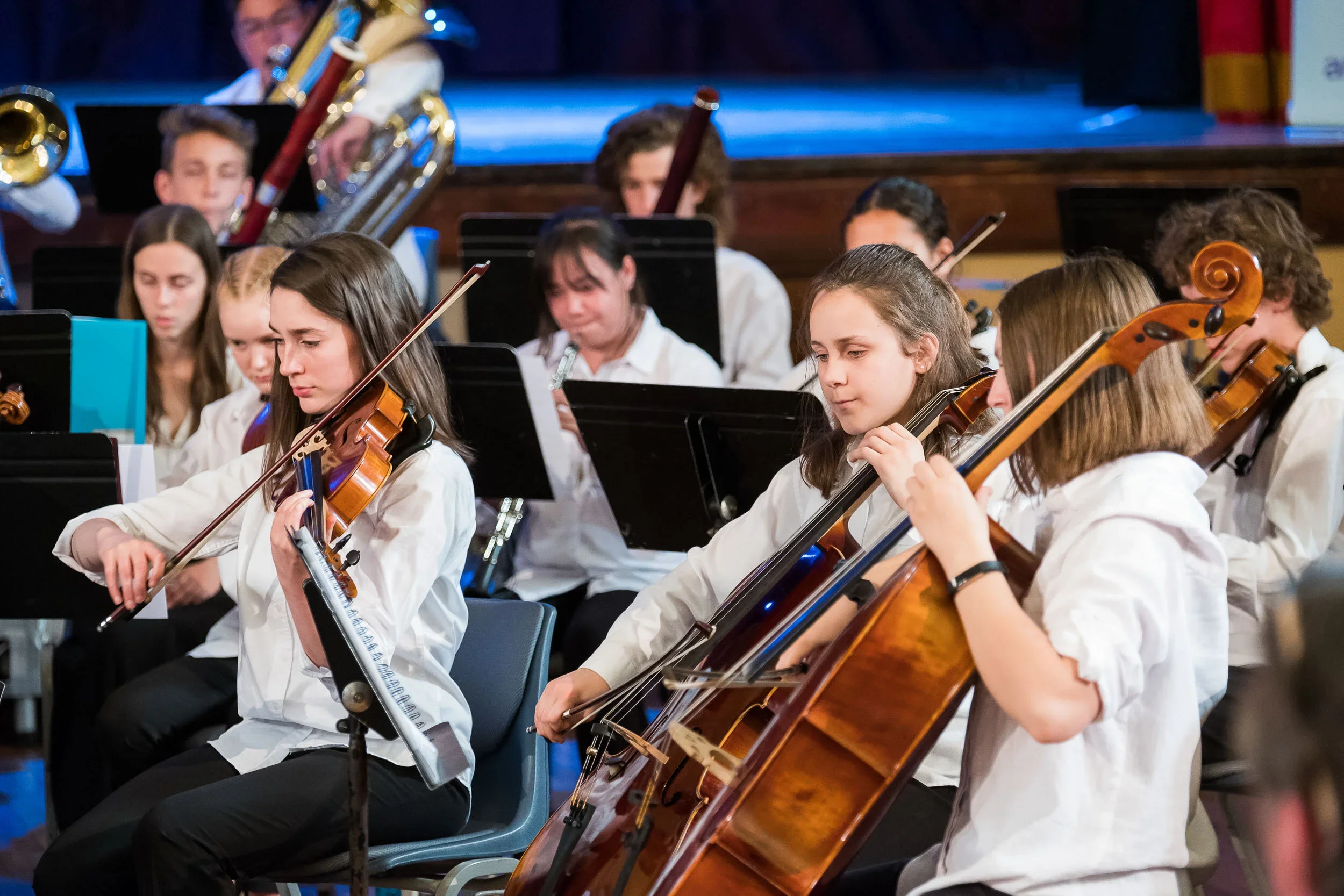 Band of young adults and teenagers performing wearing white shirts.