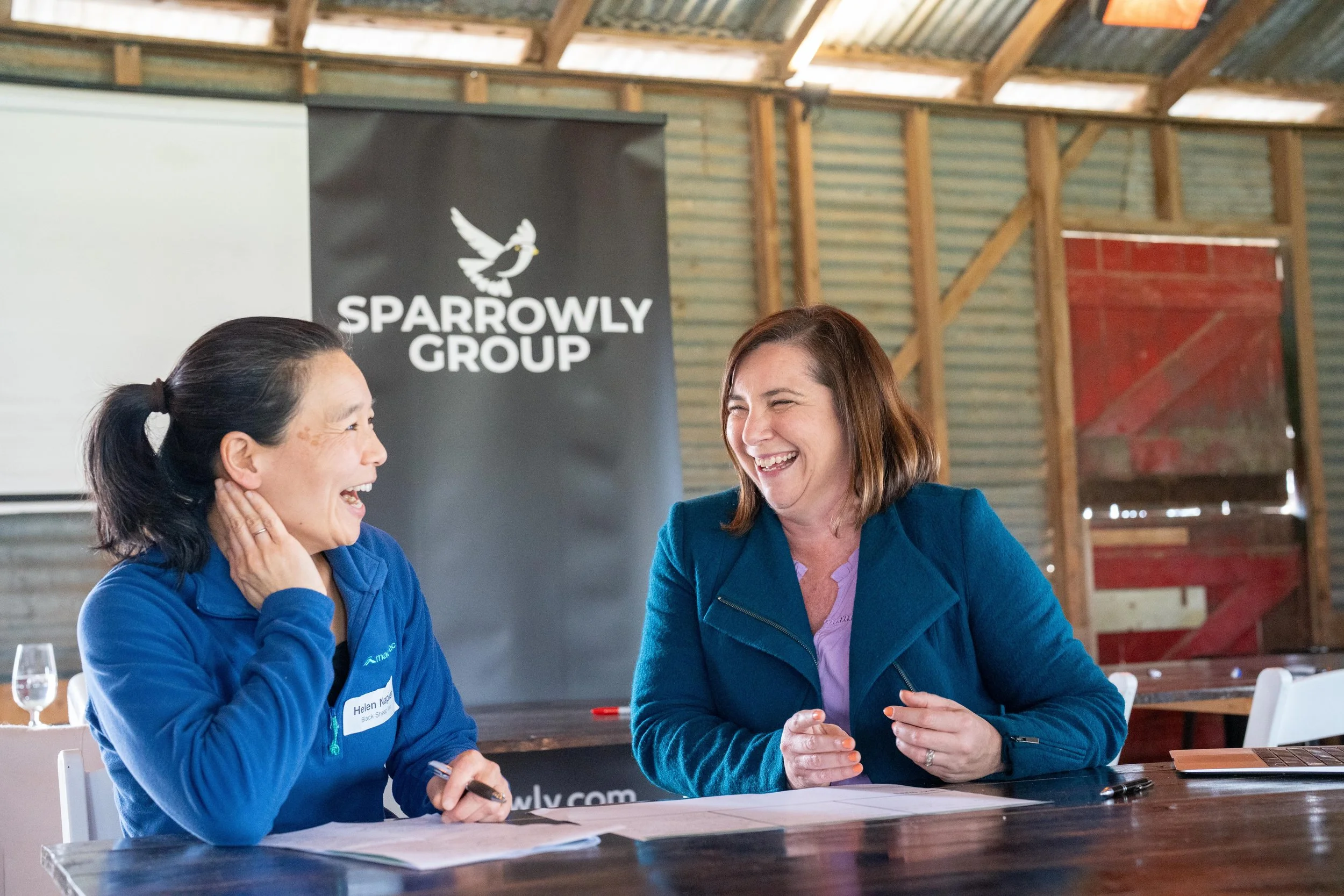 A participant and Sparrowly Group mentor share a relaxed, genuine laugh during a Sparrowly Group workshop, capturing the trust, connection and positive energy that underpin collaborative learning and meaningful engagement.