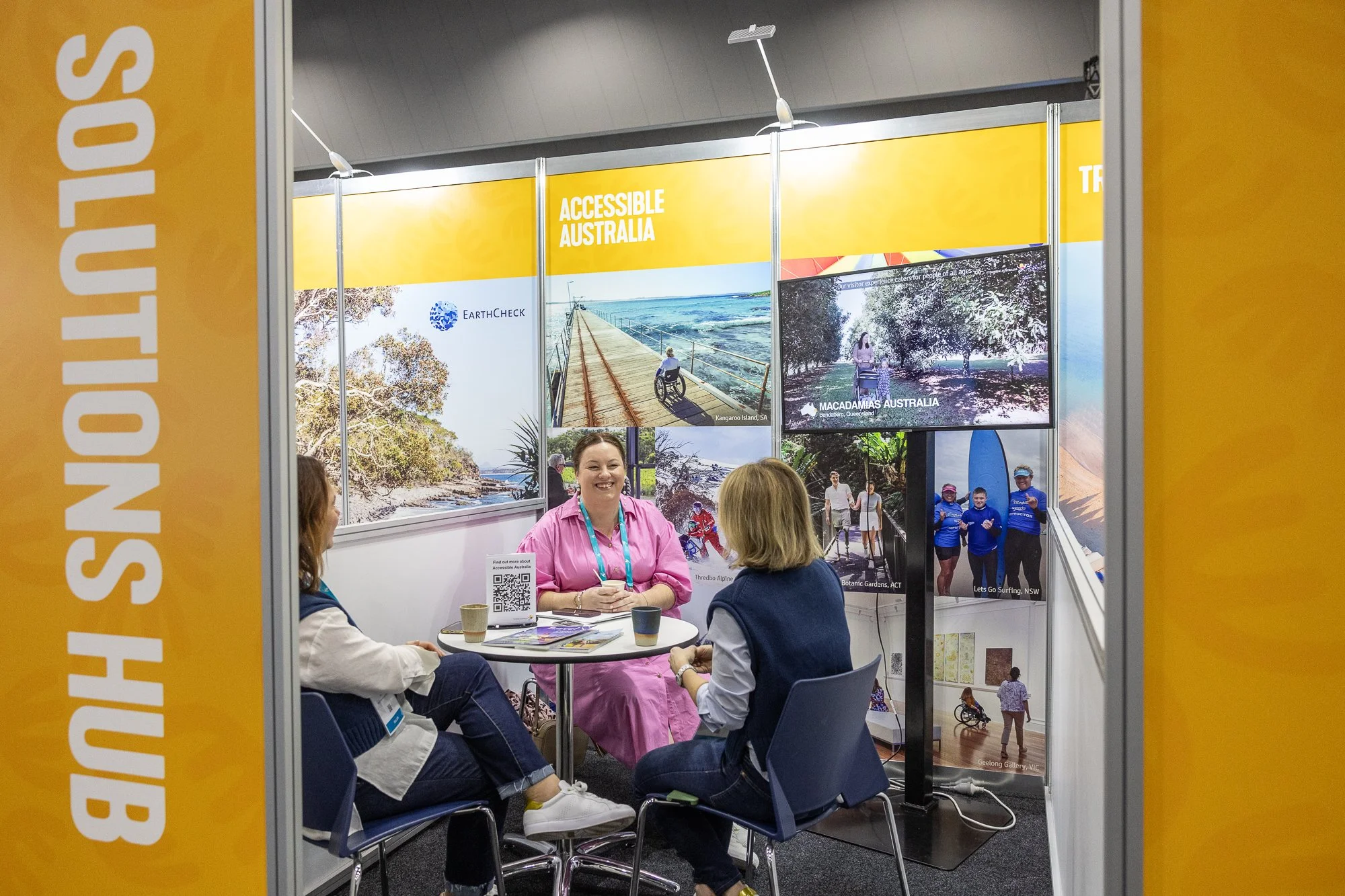 Jackie Hicks speaks with tourism operators at the Accessible Australia stand, sharing guidance and practical insights to help businesses improve accessibility and inclusive visitor experiences.