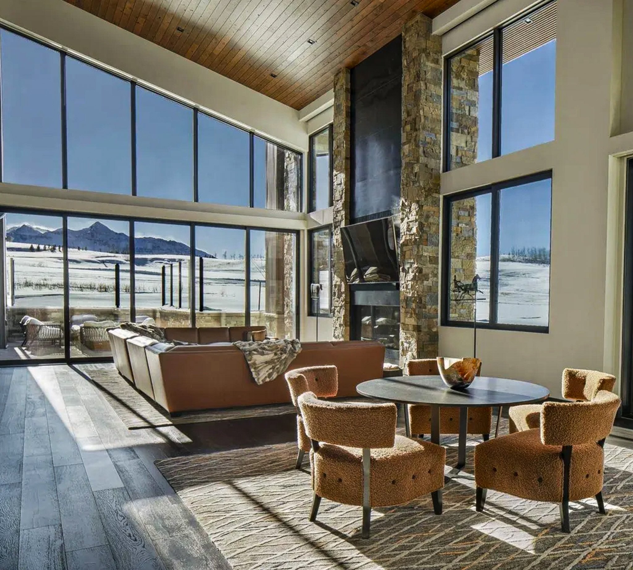 Living Room with three sided fireplace, leather sectional. Disappearing wall and sunset views.