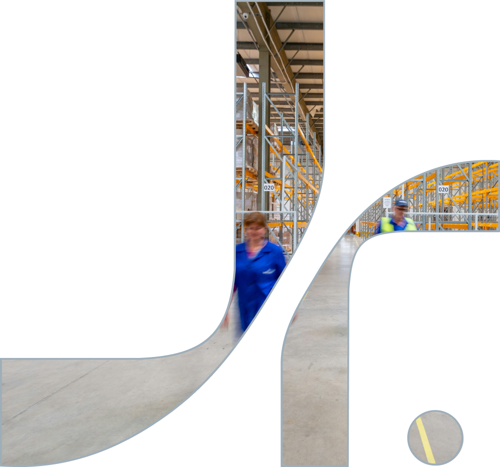 Two workers in a warehouse with tall metal shelving and packaged goods. The image is partially obscured by a large logo overlay.