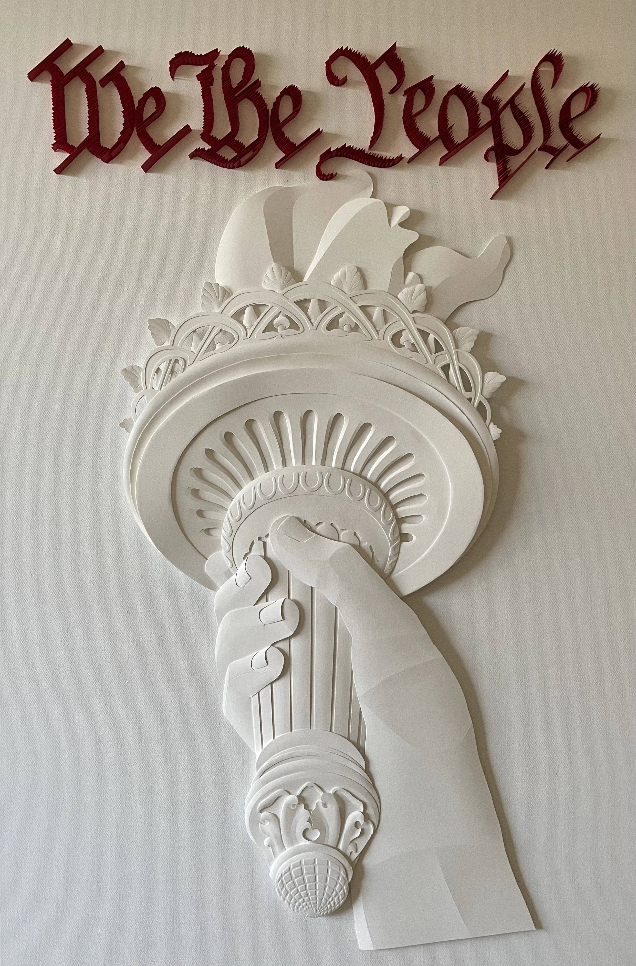 Paper sculpture of the hand of The Statue of Liberty. The Liberty torch from an alternate angle.