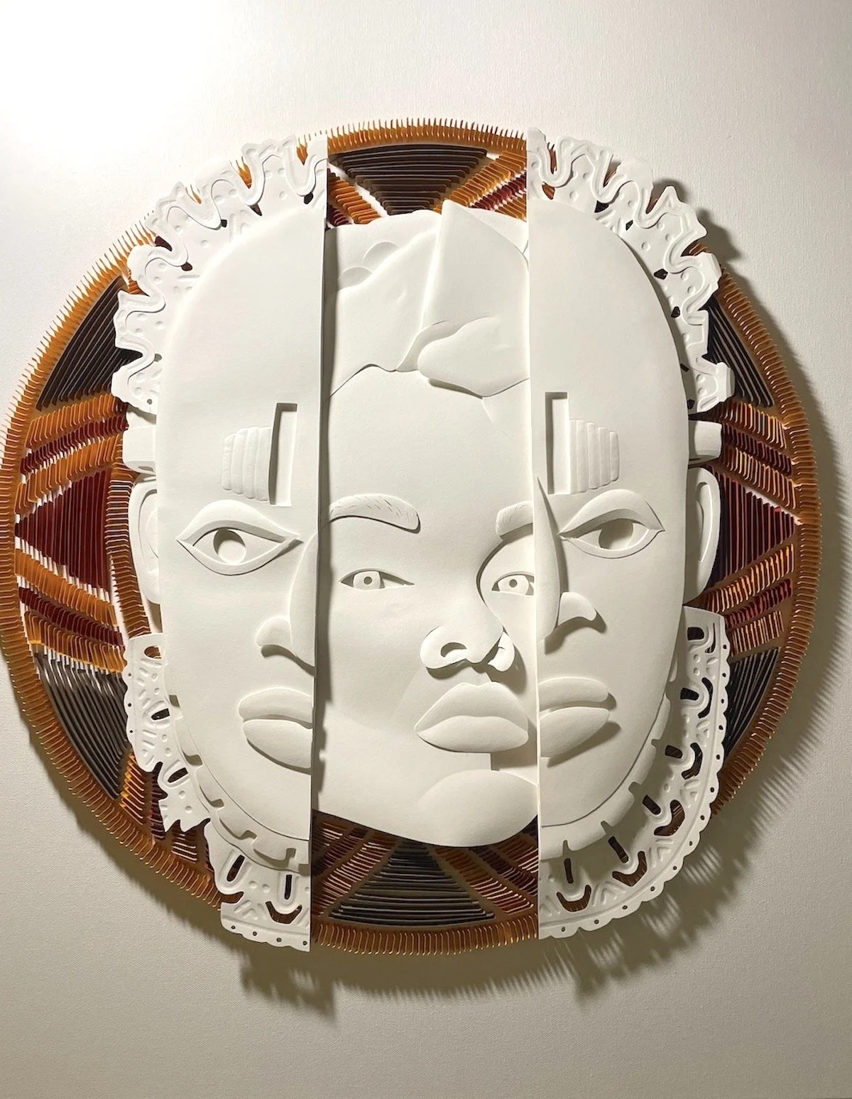 Paper sculpture of the Benin Mask. Flanked with a quilling design.