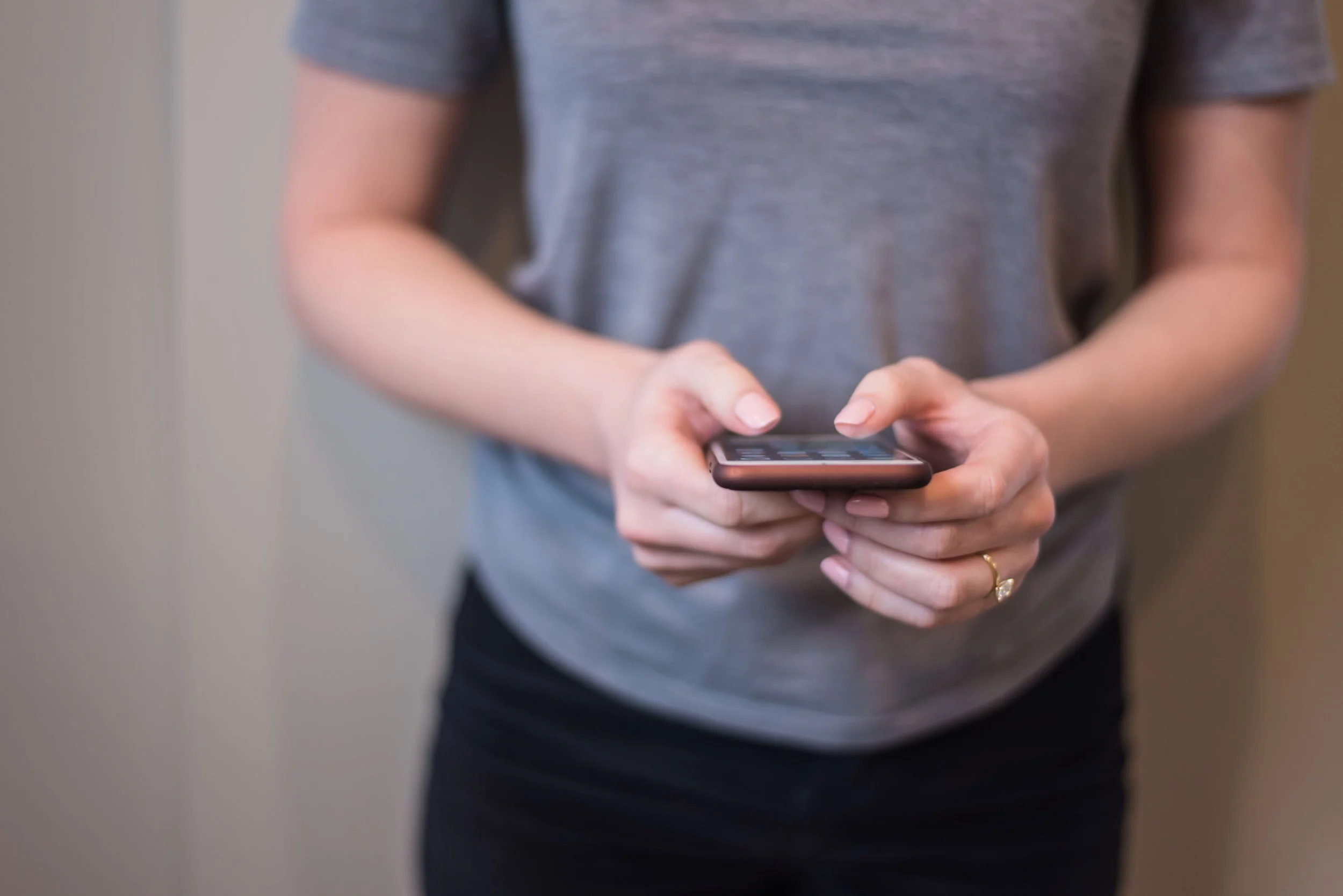 A person reviewing information on a smartphone, representing communication, engagement, and modern governance work.