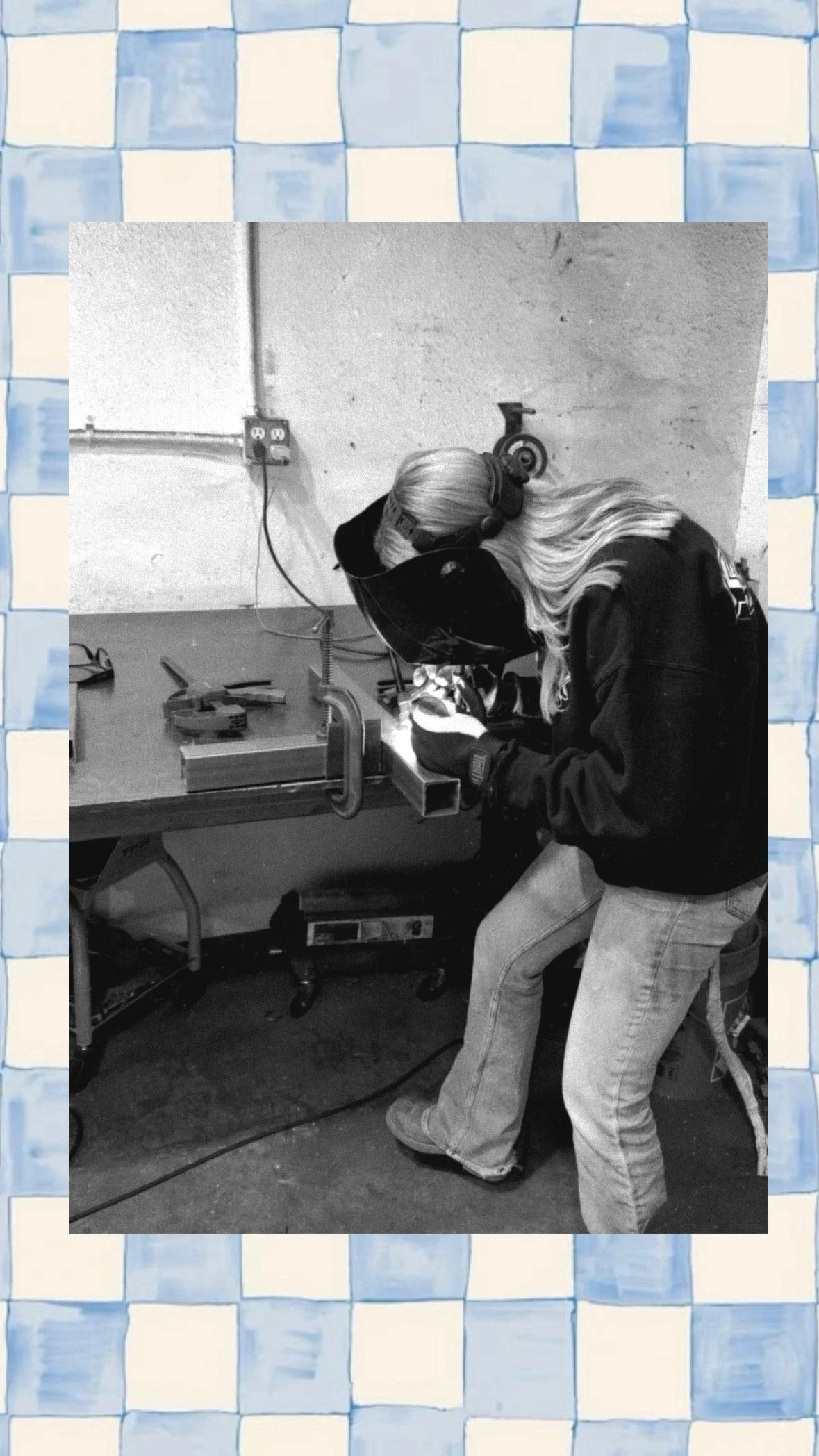 A person welding metal while wearing safety gear in a workshop.
