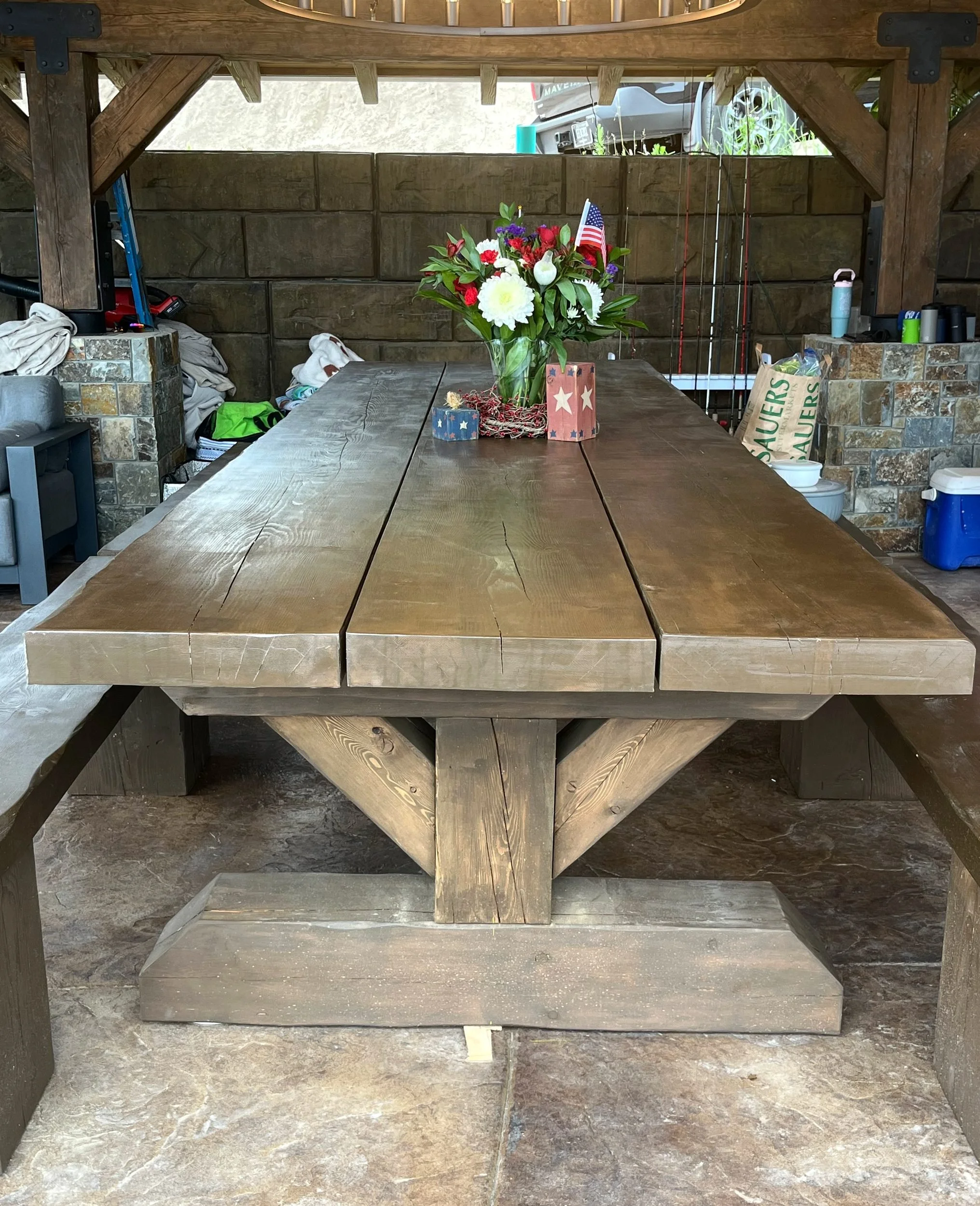 Douglas fir timber trestle table with matching benches under a timber-frame pavilion, Echo Lake MT