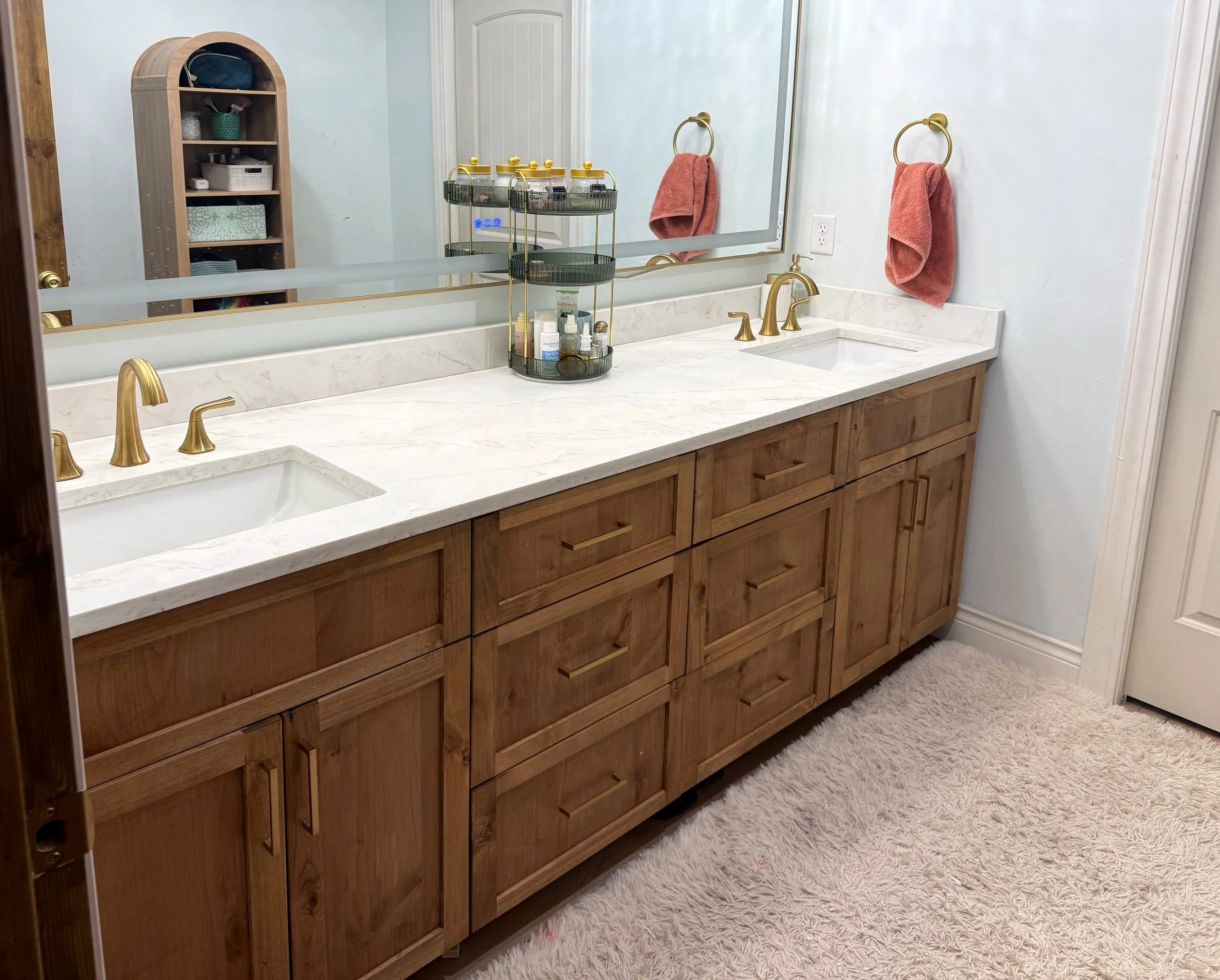 Double-sink knotty alder bathroom vanity with Shaker doors, brushed-gold pulls and a quartz countertop, Columbia Falls, Montana