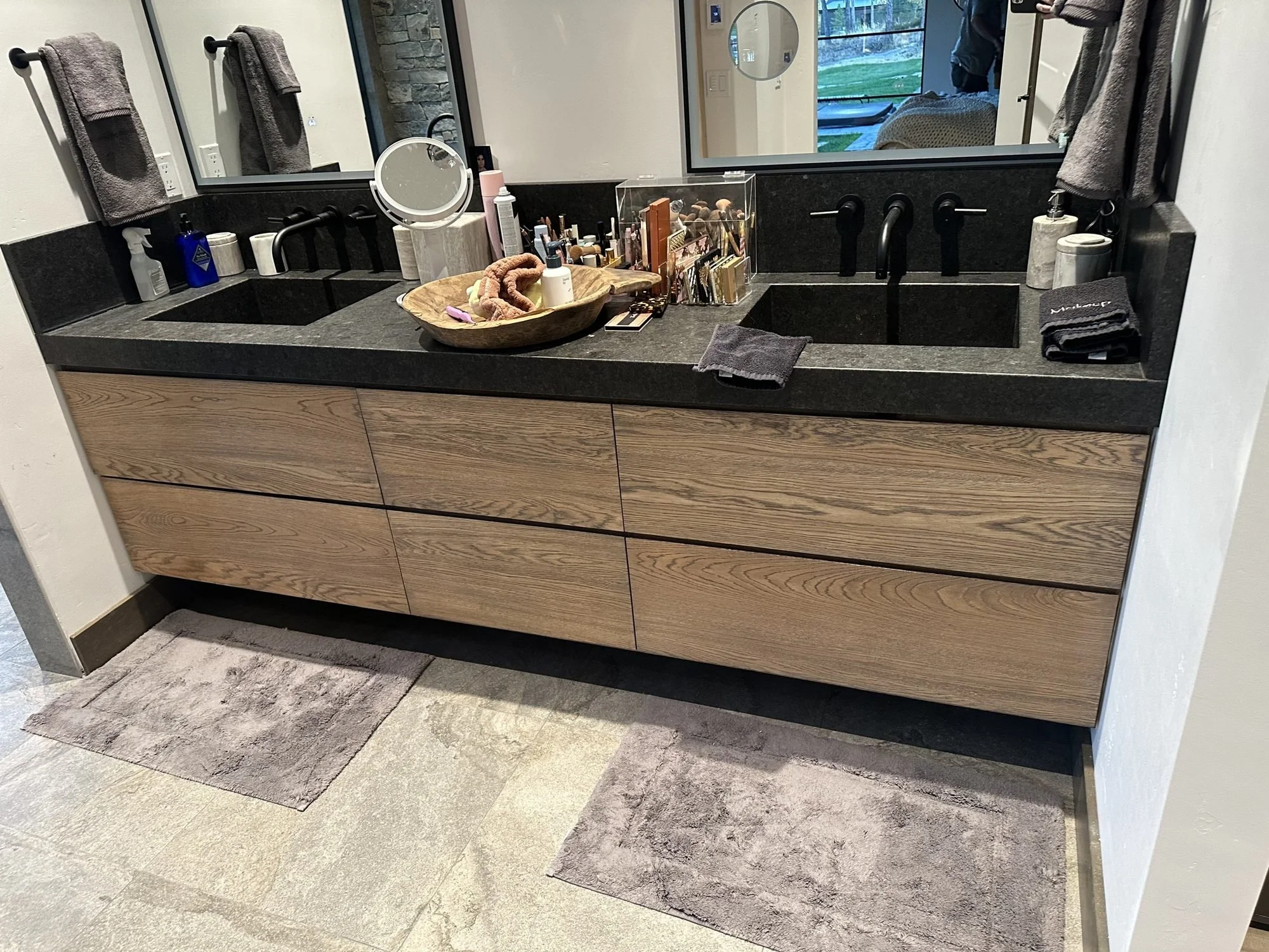 Eight-foot floating vanity in wire-brushed white oak with an aged barrel stain and double sinks