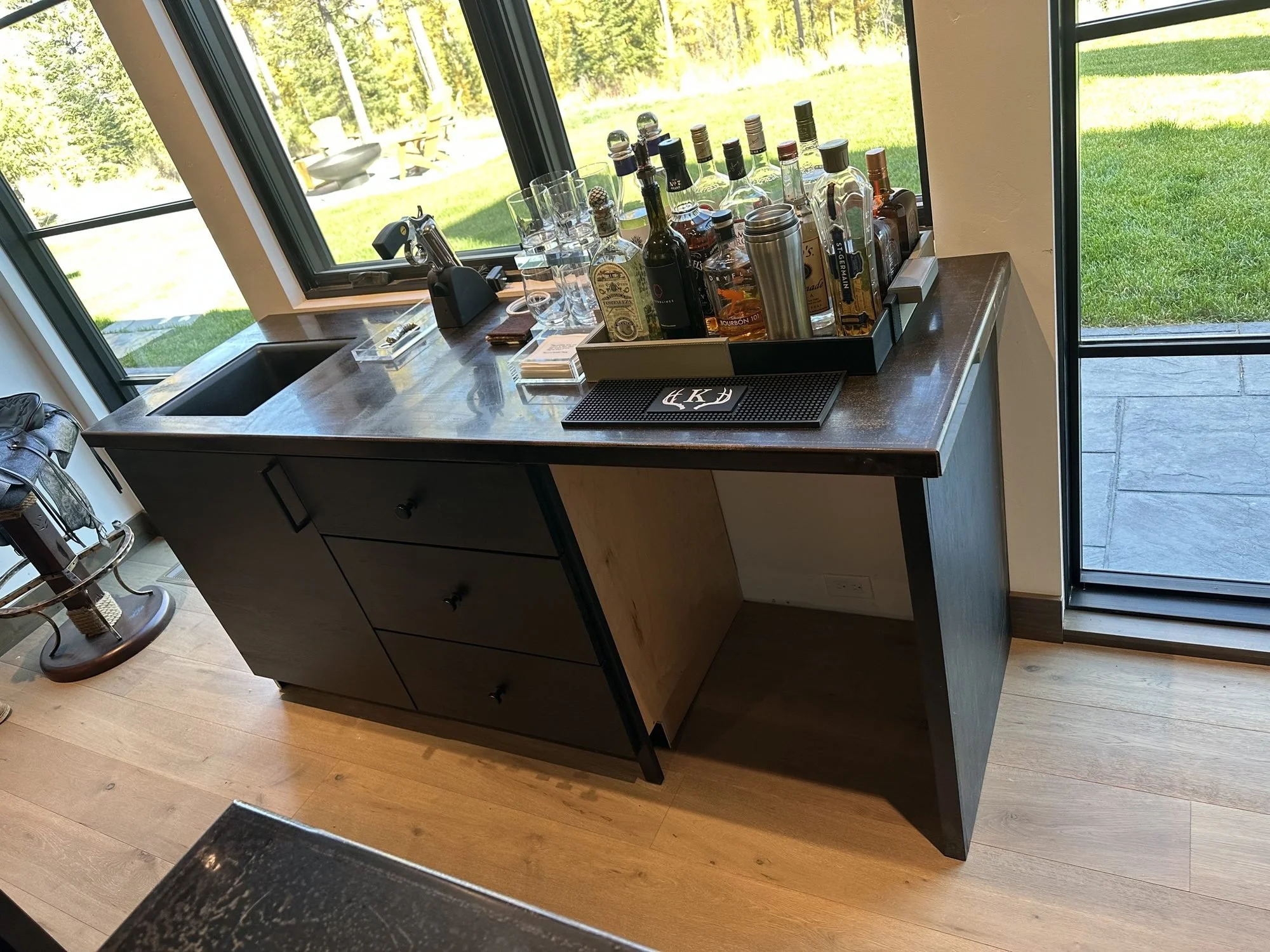 Back bar in black-stained horizontal rift-sawn white oak beneath tall windows