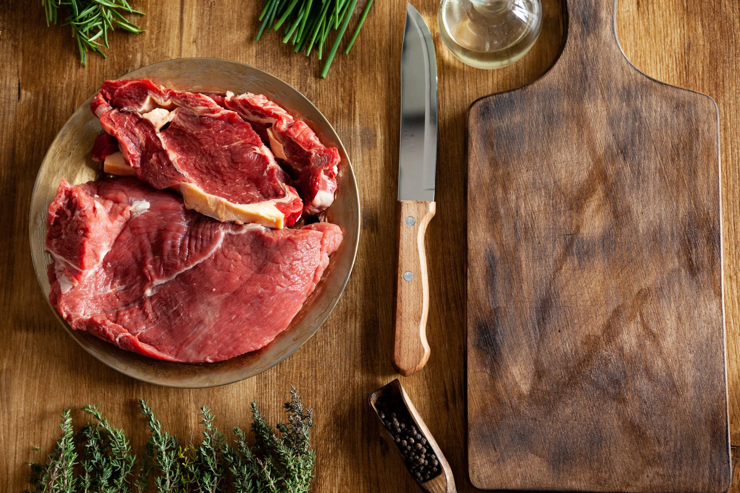 top-view-chef-knife-big-chunks-red-meat-green-vegetables-wooden-table-fresh-meat.jpg