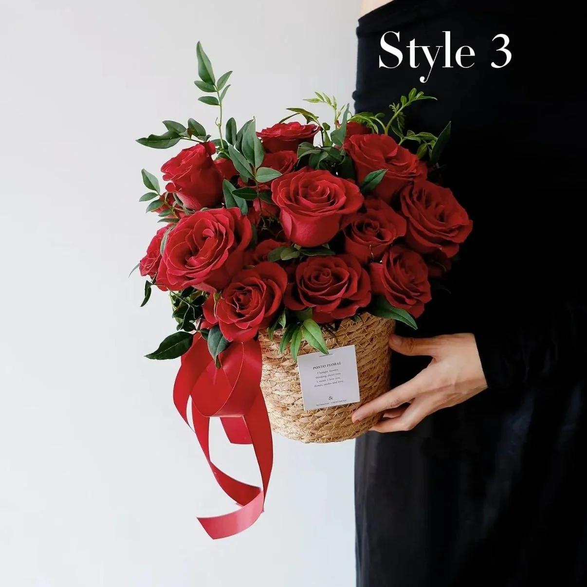 A person holding a basket of red roses with green leaves, decorated with a red ribbon, marked as Style 3.