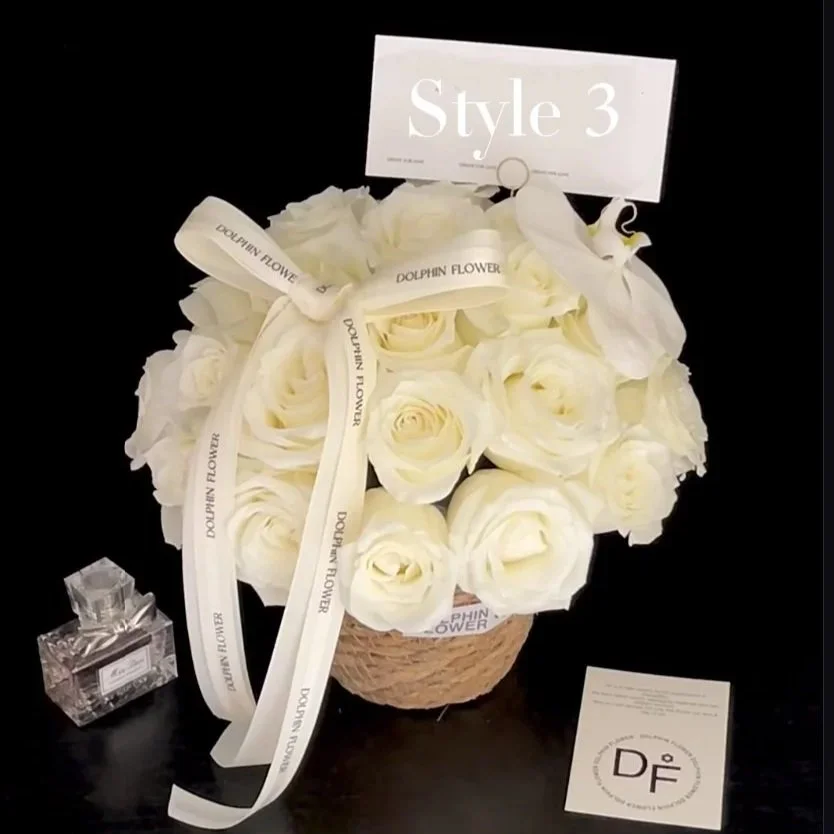 A casket-shaped arrangement of white roses with a ribbon reading 'DOLPHIN FLOWER,' a box of perfume, and a 'Style 3' card.