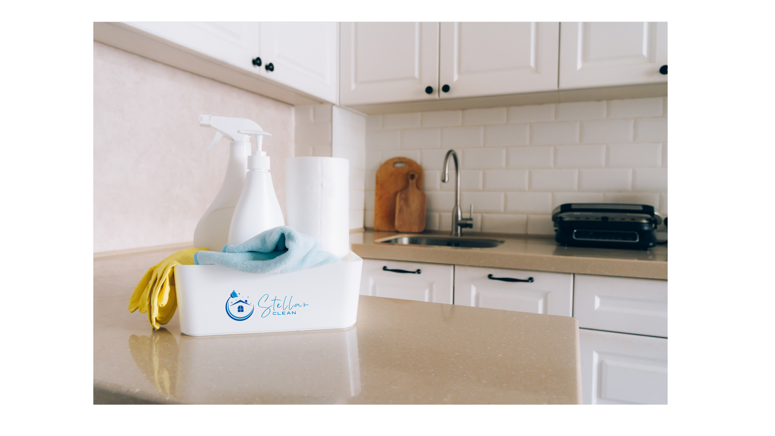 A cleaning supply caddy with spray bottles, gloves, and a cloth on a beige kitchen countertop. In the background, there are white cabinets, a brick backsplash, a wooden cutting board, a sink with a faucet, and a black toaster oven.
