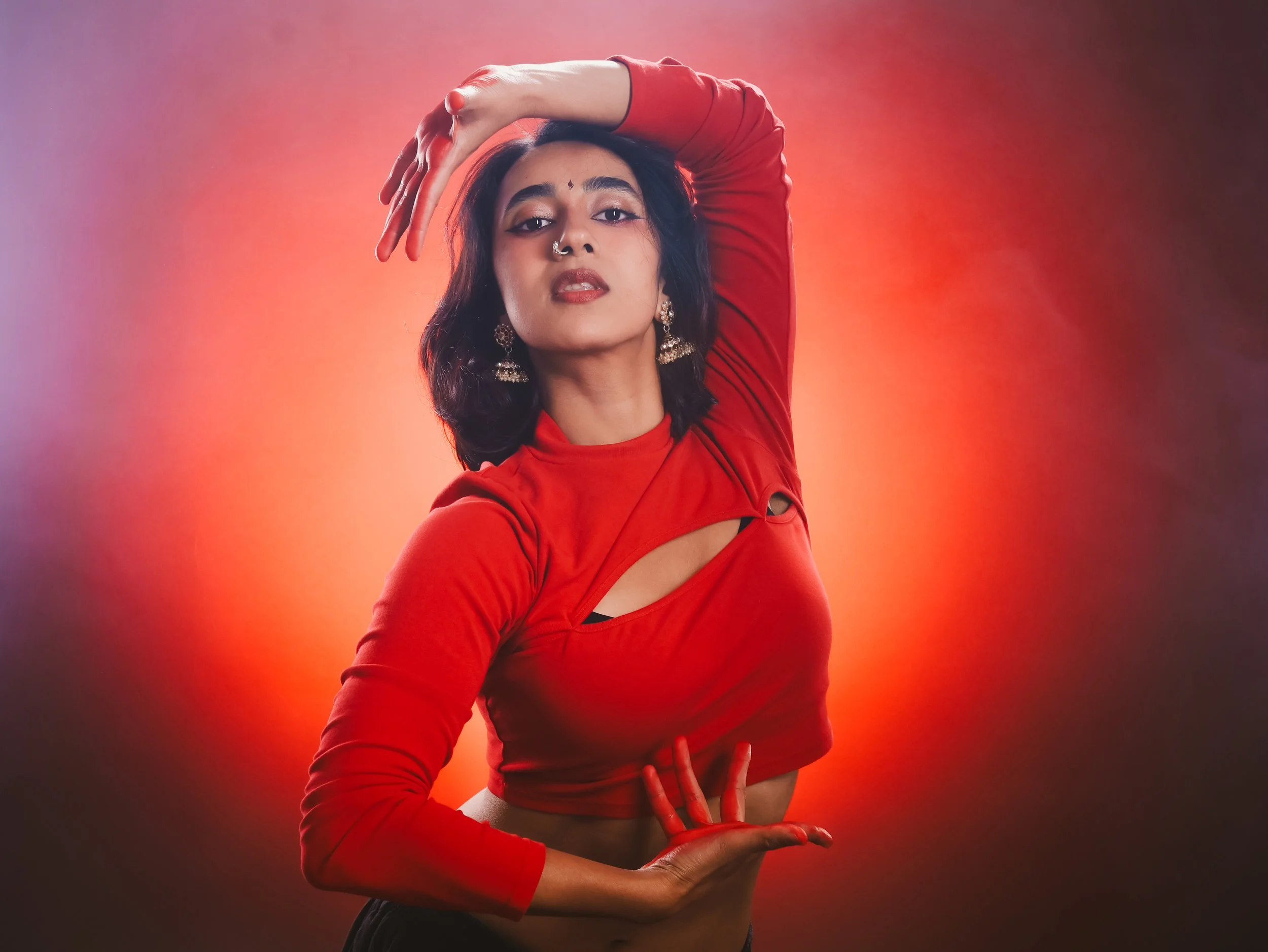 Harini is seen posing with her hands painted red and framing her face